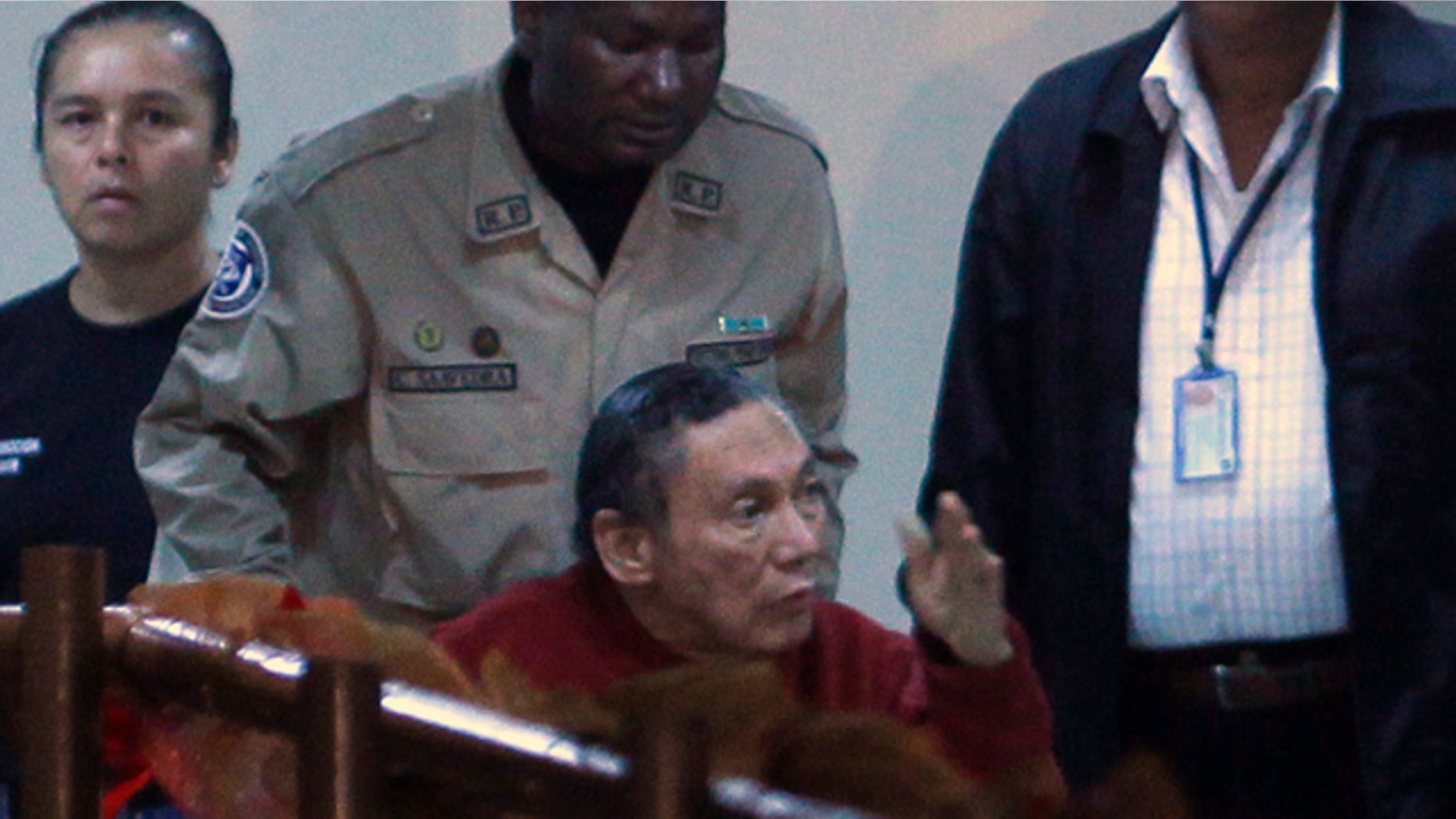 Dec. 11, 2011: Panama's former strongman Manuel Noriega gesturing while being carried in a wheelchair by a police officer inside El Renacer prison, on the outskirts of Panama City.