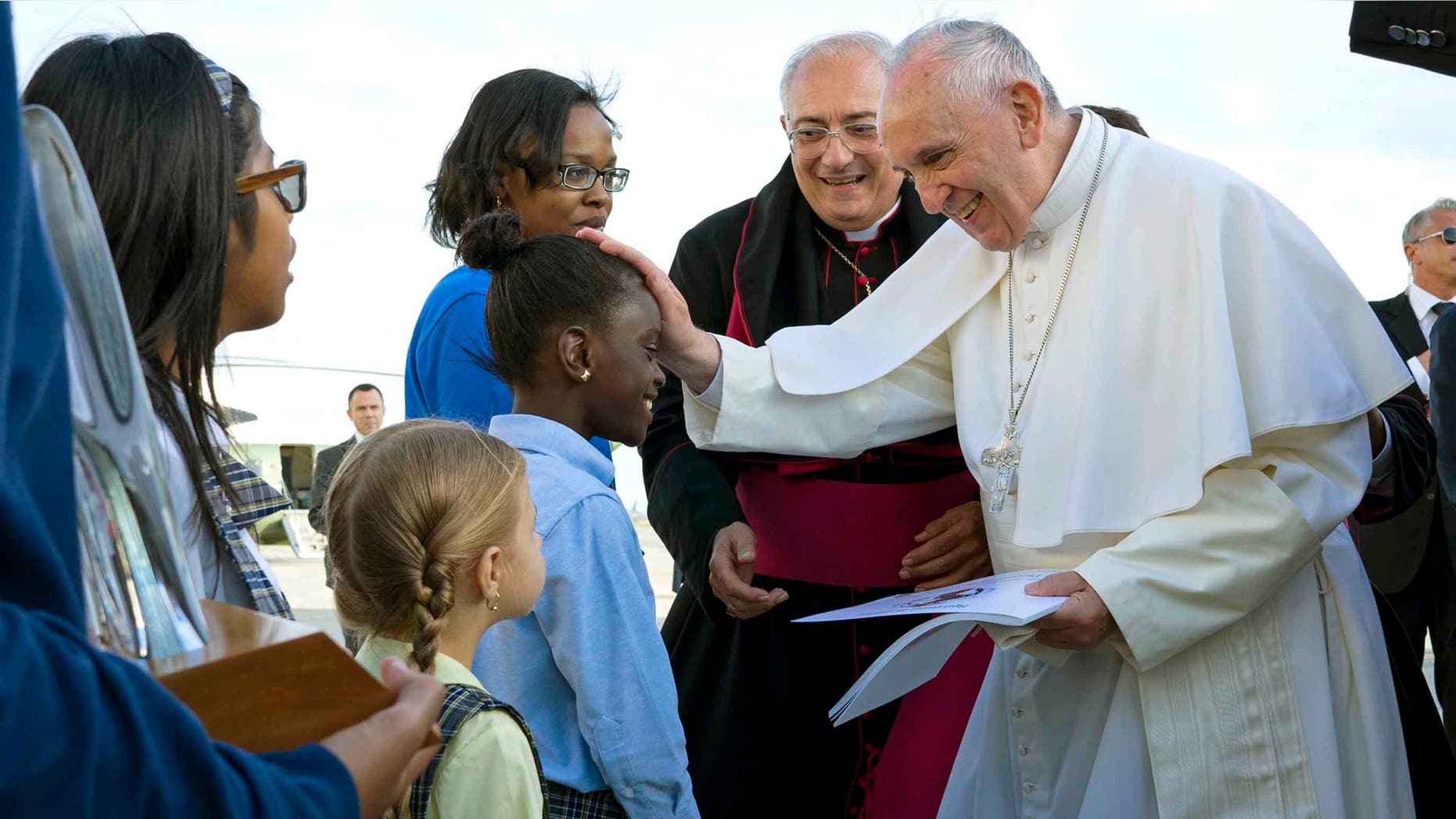 Pope Francis reaches out to 5th grader Omodele Ojo, of the Brooklyn borough of New York, as he is greeted while arriving at John F. Kennedy International Airport Thursday, Sept. 24, 2015, in New York. (AP Photo/Craig Ruttle, Pool)