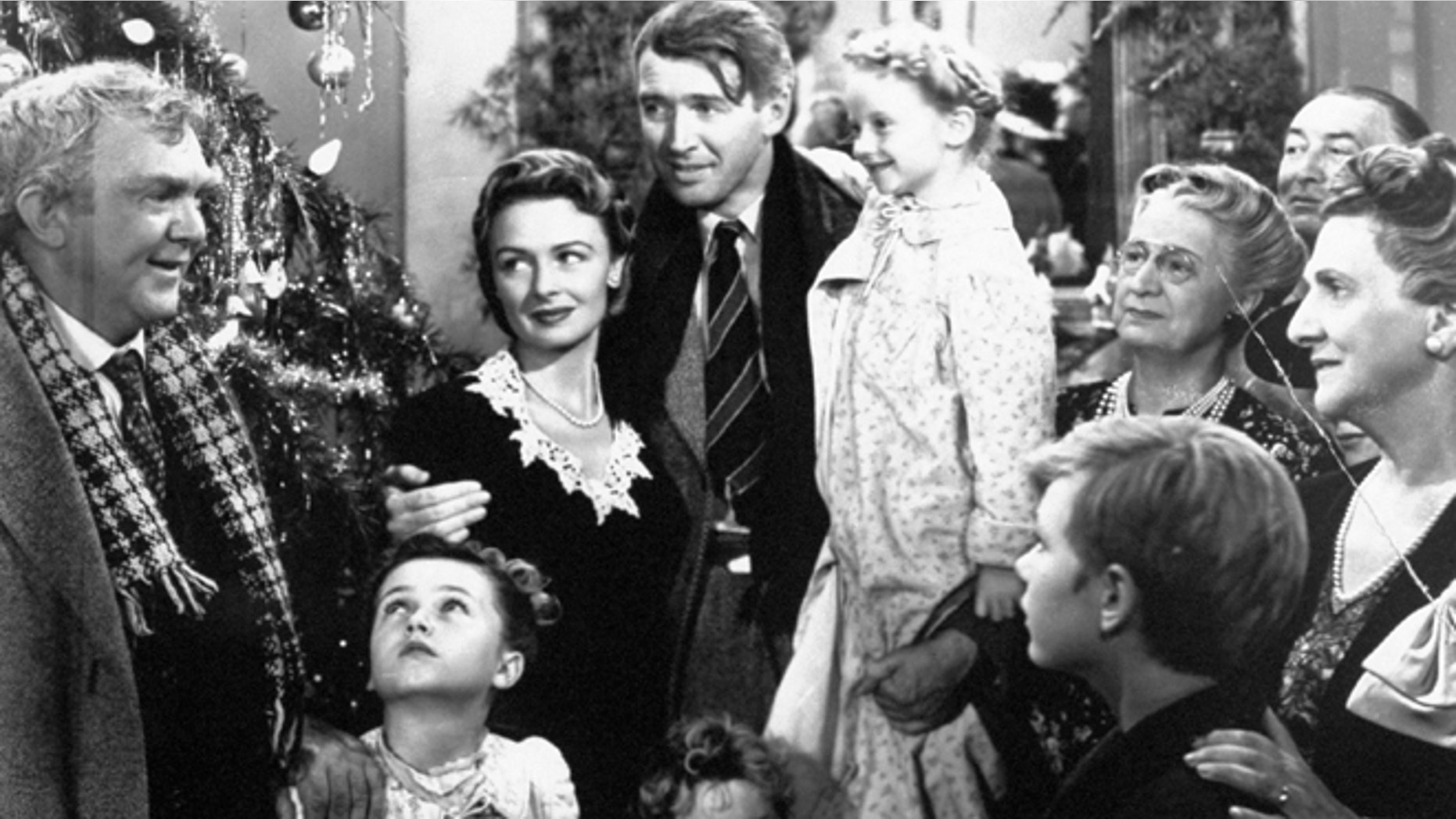 In this 1946 file photo originally provided by RKO Pictures Inc., legendary actor James Stewart as George Bailey, center, is reunited with his wife played by actress Donna Reed, third from left, and family during the last scene of Frank Capra's "It's A Wonderful Life."
