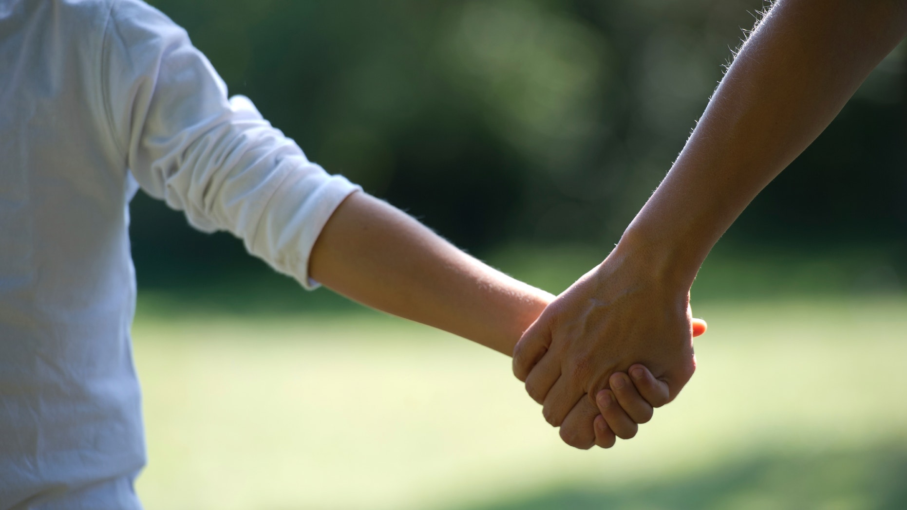 A mother holds his child's hand