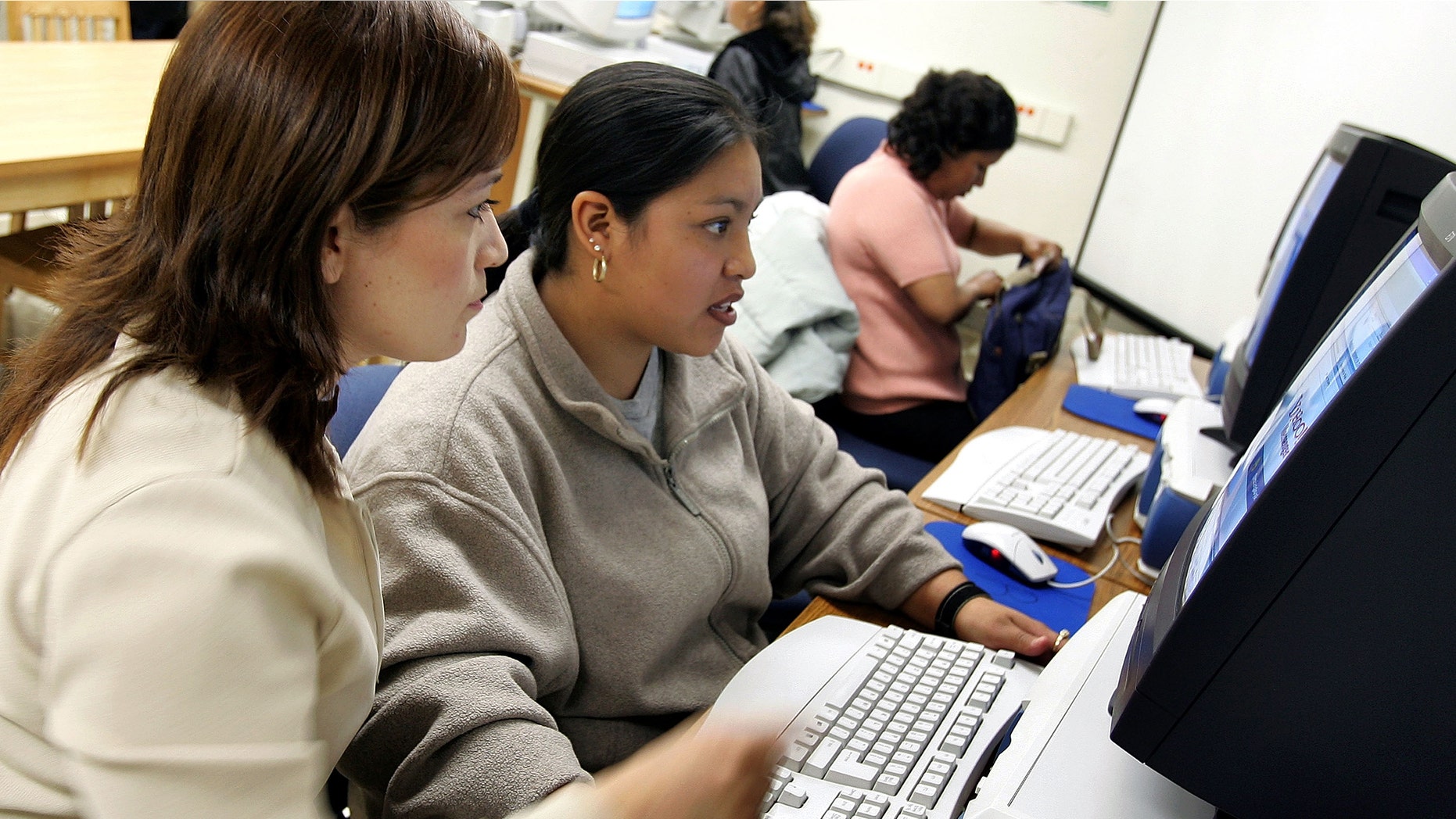 CHICAGO - MAY 02: Class instructor Ana Arredondo (L) assists student Rosa Galan at the Community Learning Resource Center May 2, 2005 at Perez Elementary School in the largely Hispanic Pilsen neighborhood in Chicago, Illinois. Spanish-speaking parents of Chicago Public School (CPS) students will have the opportunity to learn basic computer skills at no cost through a partnership between the CPS Office of Language and Cultural Education and the Mexican university Tecnologico de Monterrey, in Monterrey, Mexico. Upon completion of the 16-week program, parents will receive a diploma from the Tecnologico de Monterrey. (Photo by Tim Boyle/Getty Images)