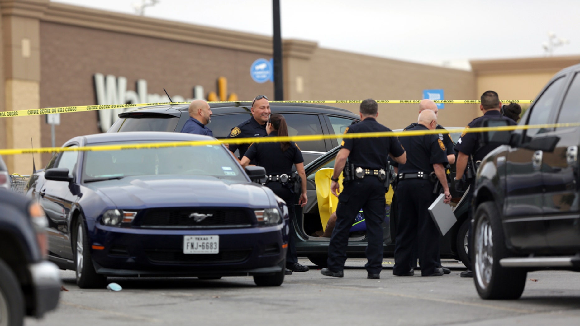 San Antonio police investigate the scene of a shooting in the Wal-Mart parking lot in San Antonio, Friday, Nov. 25, 2016.