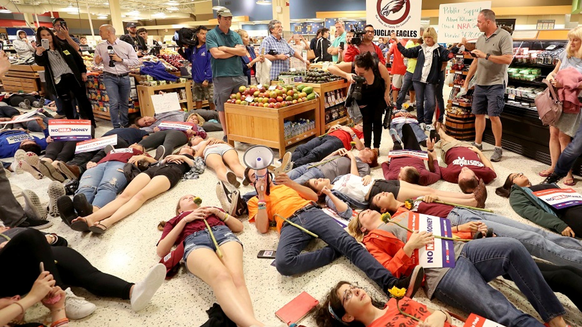 Demonstrators lie on the floor at a Publix Supermarket in Coral Springs, Fla., Friday, May 25, 2018.