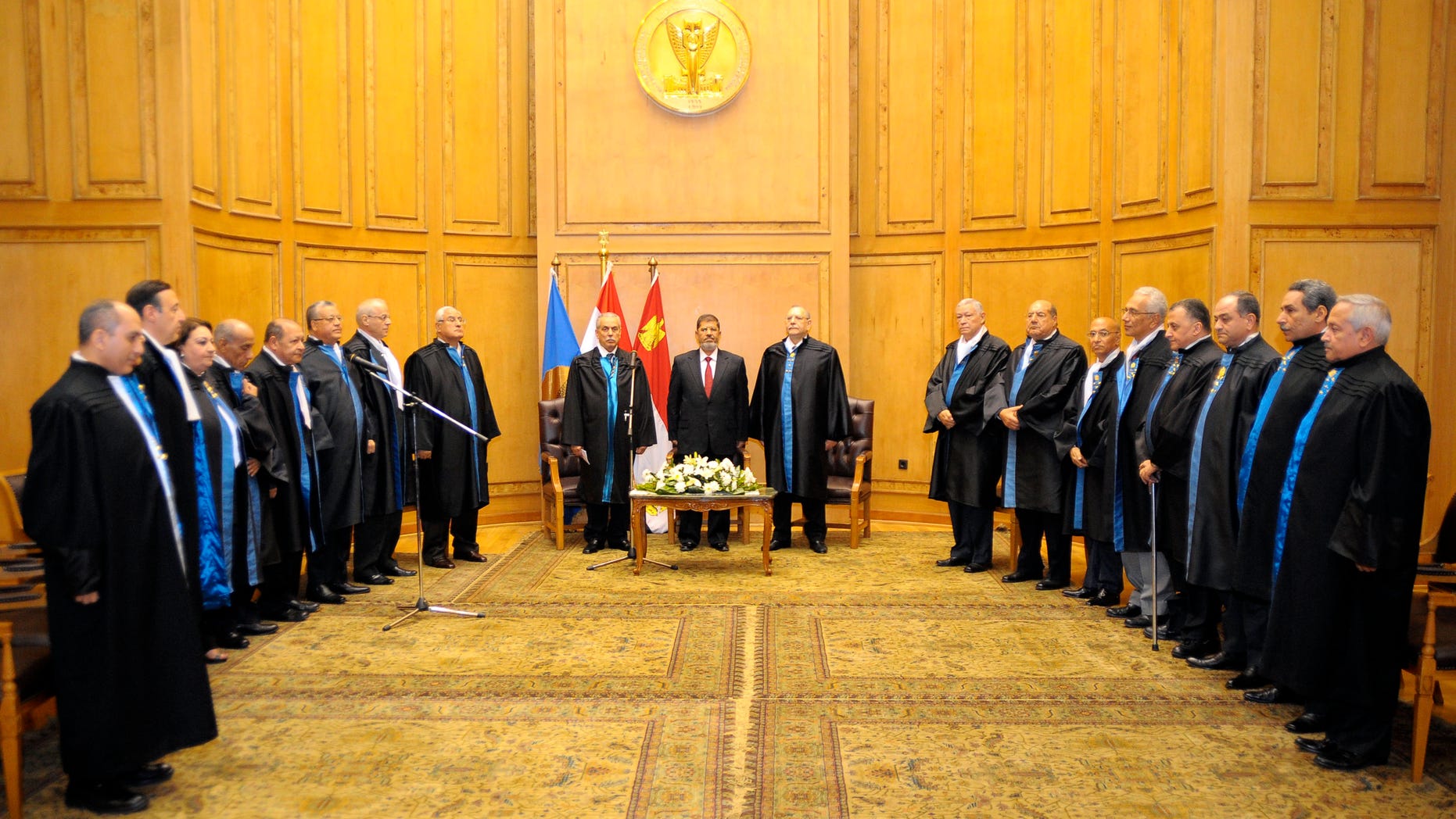 In this image released by the Egyptian President, Egyptian President Mohammed Morsi, center left, stands with judges Farouk Sultan, second left, and Maher el-Beheri, center right, as he is sworn in at the Supreme Constitutional Court in Cairo, Egypt, Saturday, June 30, 2012. Islamist Mohammed Morsi promised a "new Egypt" and unwavering support to the powerful military as he took the oath of office Saturday to become the country's first freely elected president, succeeding Hosni Mubarak who was ousted 16 months ago. (AP Photo/Egyptian Presidency)