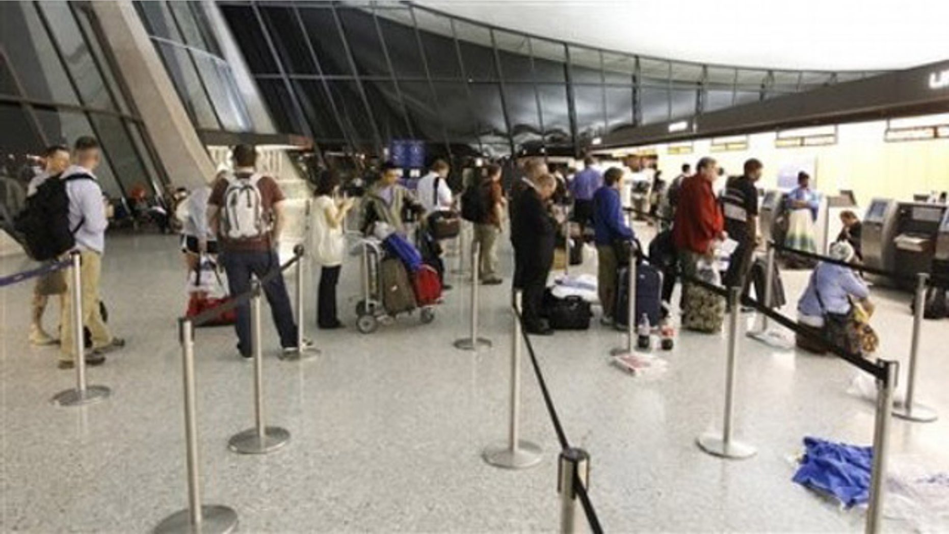 Airline passengers wait at the ticket counter of Washington Dulles International Airport in Chantilly, Va., June 18.