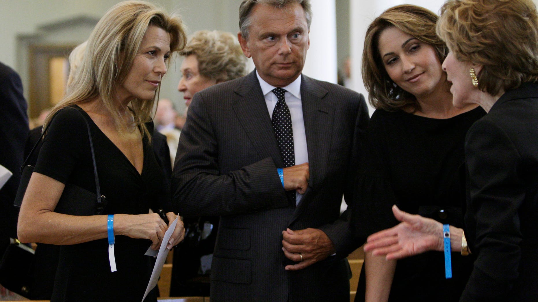 Vanna White (L) and Pat Sajak (C), television personalities from the 'Wheel of Fortune' game show created by Merv Griffin, and Sajak's wife Lesly Brown Sajak (2nd R) listen to an unidentified woman prior to funeral services for Griffin in Beverly Hills, California, August 17, 2007. Griffin died August 12, 2007 of prostate cancer at the age of 82. REUTERS/Kevork Djansezian/Pool (UNITED STATES) - RTR1SVAK