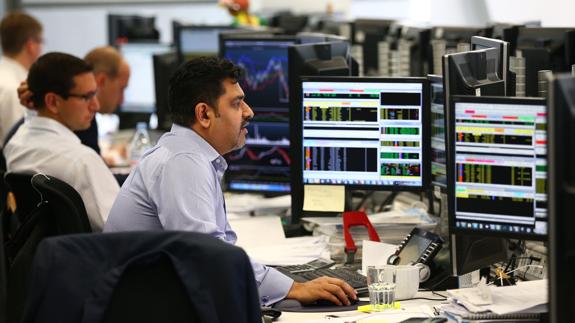 LONDON, ENGLAND - OCTOBER 20: An employee views trading screens at the offices of Panmure Gordon and Co on October 20, 2014 in London, England. Markets stabilised over the weekend following global turbulence amid fears over the Ebola virus and global economic concerns. (Photo by Carl Court/Getty Images)