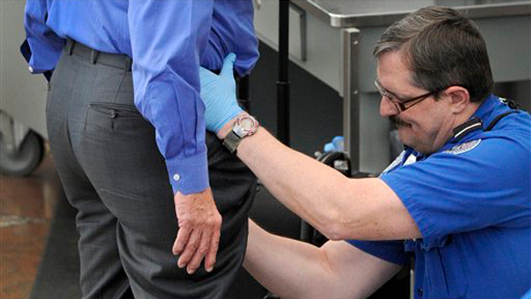 In this Nov. 17 photo, a Transportation Security Administration agent performs an enhanced pat-down on a traveler at Denver International Airport. (AP Photo)