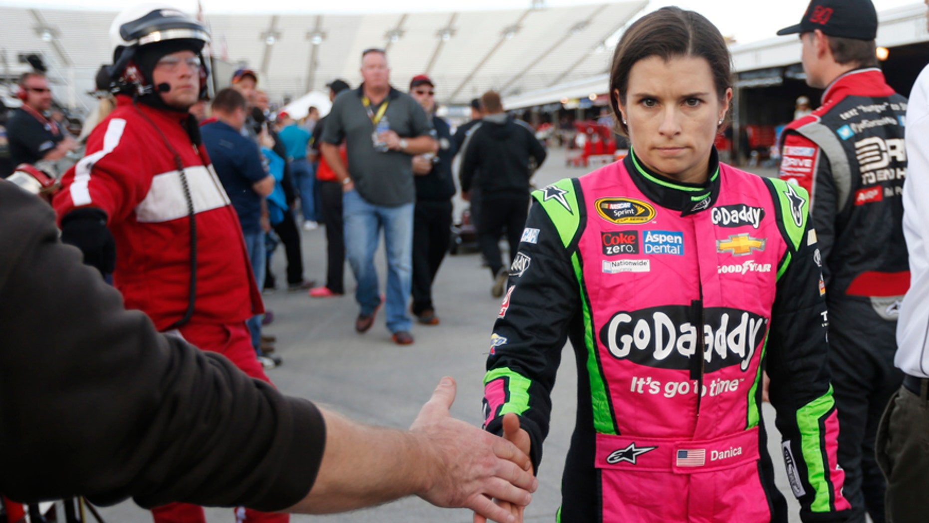Danica Patrick shakes the hand of a fan as she heads to her hauler after qualifying for Sunday's Sprint Cup Series auto race at Martinsville Speedway in Martinsville, Va., Friday, Oct. 24, 2014. (AP Photo/Steve Helber)