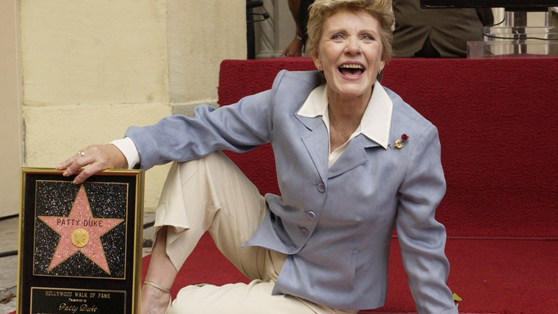 Award-winning actress Patty Duke poses for photographers following an unveiling ceremony, honoring her with the 2,260th star on the Hollywood Walk of Fame in Los Angeles, California August, 17, 2004.