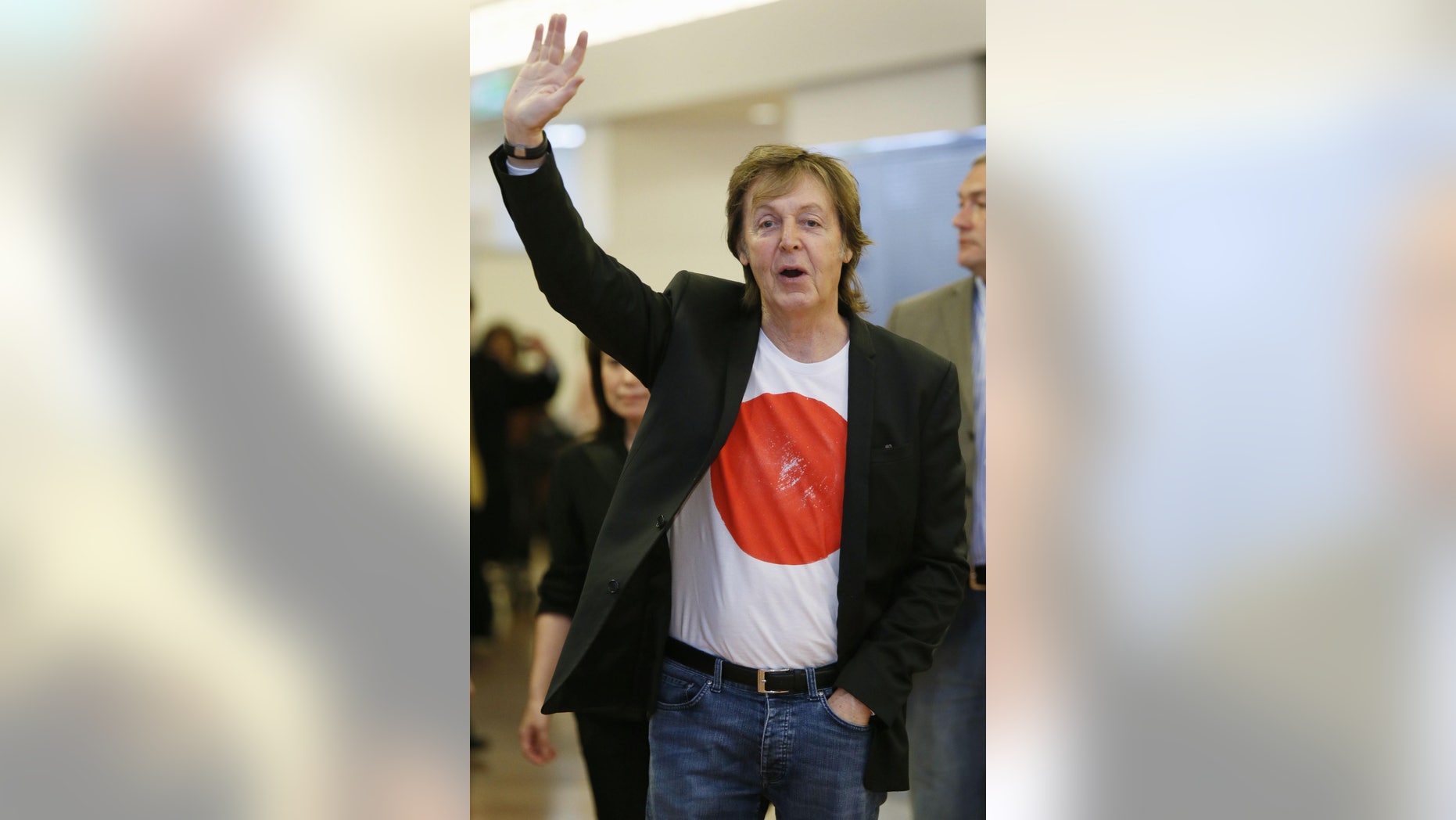 May 15, 2014. Singer Paul McCartney waves to fans upon his arrival at Tokyo';s Haneda international airport.