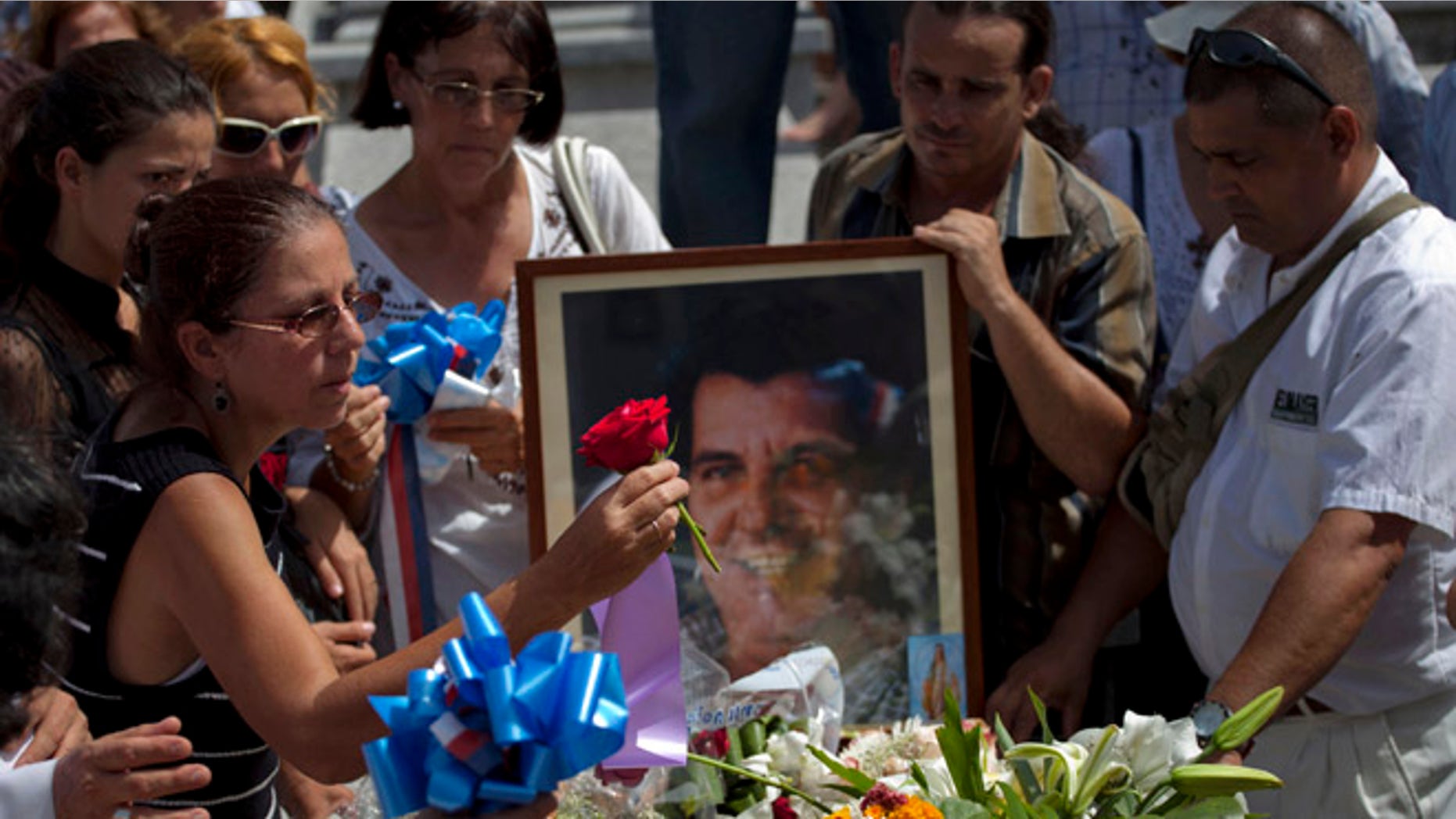 Ofelia Acevedo, viuda del difunto activista cubano Oswaldo Payá, coloca una flor sobre el ataúd durante el entierro en La Habana, martes 24 de julio de 2012. Payá, de 60 años, ganó fama internacional como promotor del Proyecto Varela, una campaña de firmas hace 10 años para pedir a las autoridades las libertades de expresión y reunión, entre otras. Fue considerada la iniciativa no violenta más grande para lograr cambios en el sistema cubano. Payá murió el 22 de julio de 2012 en un accidente automovilÃstico. (AP Foto/Ramón Espinosa)