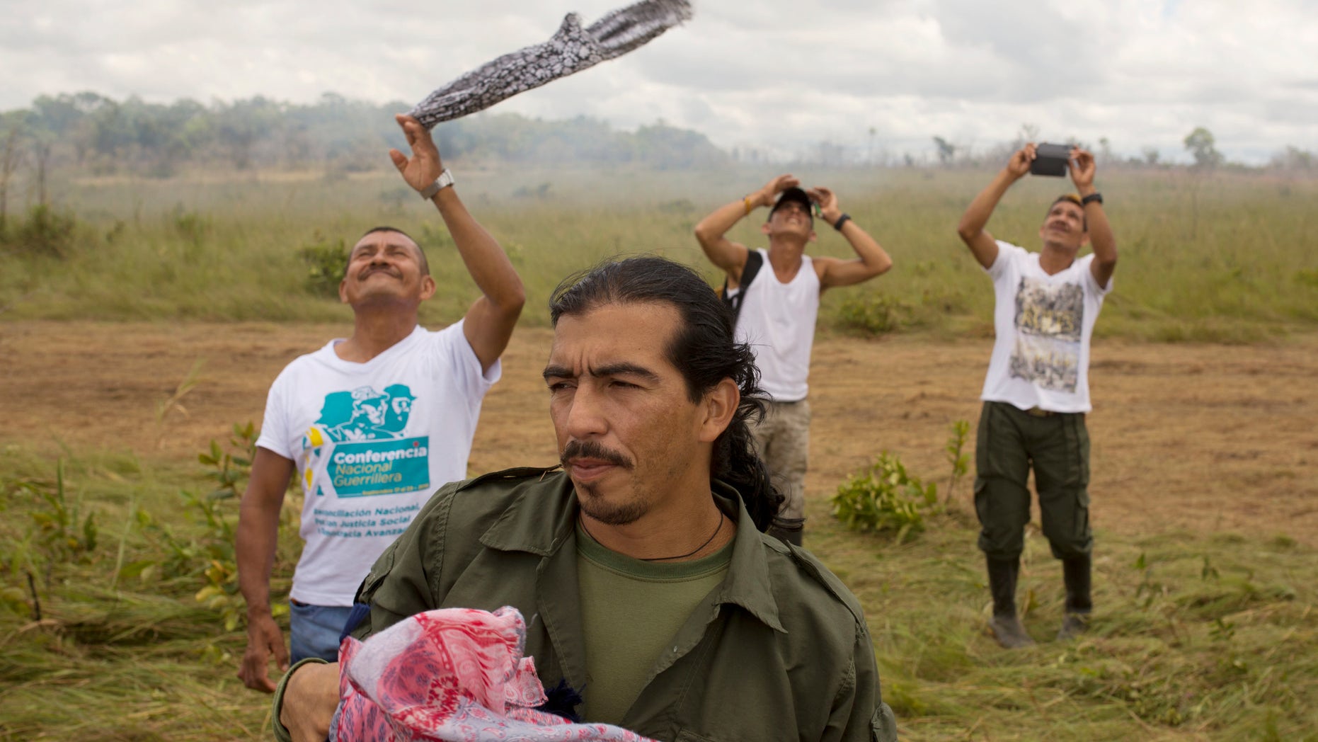 Rebels wave as a helicopter transporting FARC leaders takes off from Yari Plains, Colombia, Sept. 24, 2016.