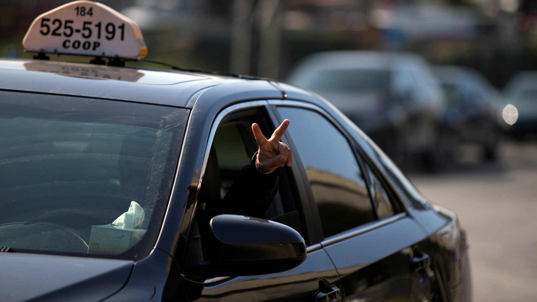 File photo - A taxi driver flashes a peace sign as he and other taxi drivers begin their protest against Uber in Montreal, Canada Oct. 5, 2016. (REUTERS/Christinne Muschi)
