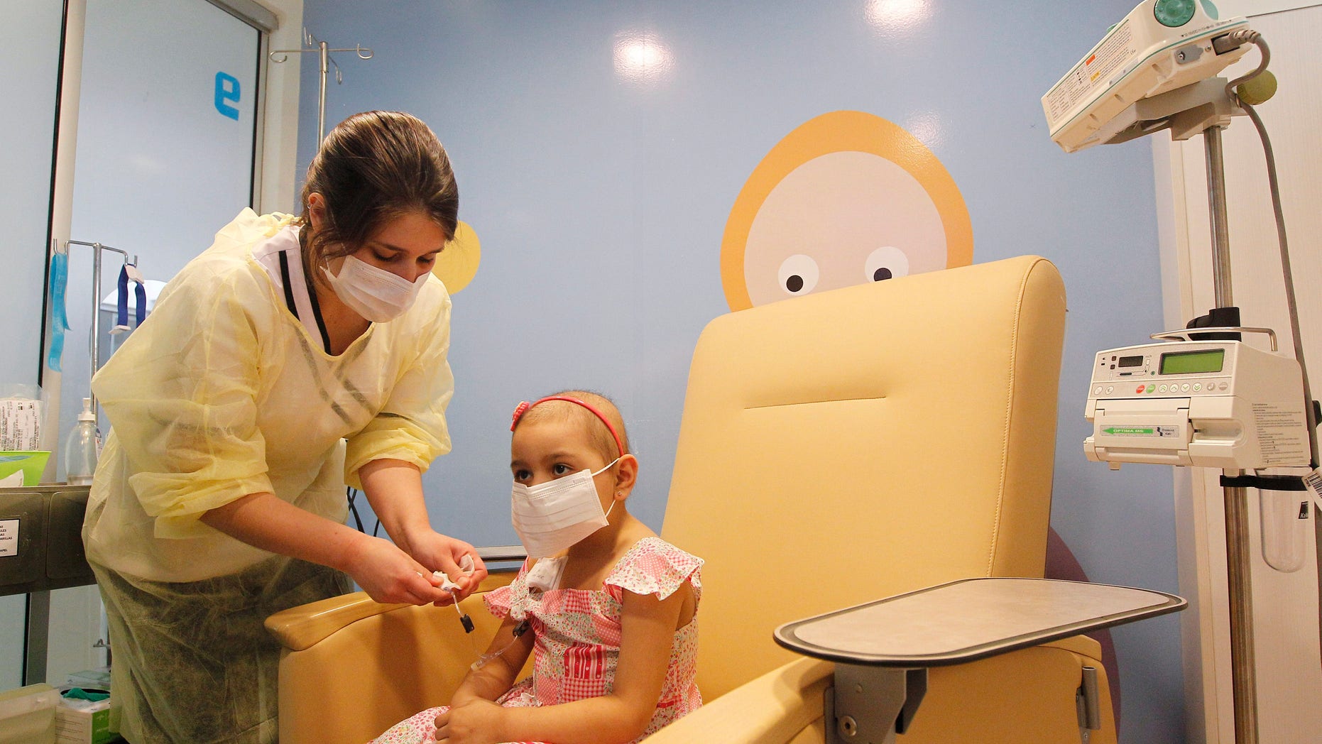Alexandra Munoz, 5, who lost her hair due to chemotherapy to treat a malignant brain tumor, undergoes a session of treatment with the help of a nurse in the cancer ward of the Luis Calvo Mackenna Hospital in Santiago, October 20, 2014. REUTERS/Rodrigo Garrido