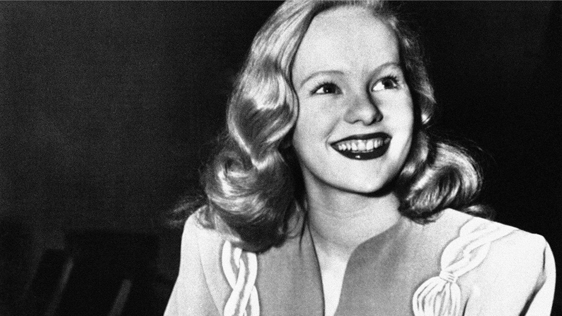 FILE - In this Dec. 26, 1945, file photo, actress Peggy Cummins, 20, smiles in Superior Court, in Los Angeles, after her contract with Twentieth Century-Fox Studio had been approved. Cummins, who gave an indelible performance as the lethal, beret-wearing robber in the noir classic "Gun Crazy," has died. Cummins, who retired from acting in the early 1960s, died Friday, Dec. 29, 2017, in London at age 92. (AP Photo/File)