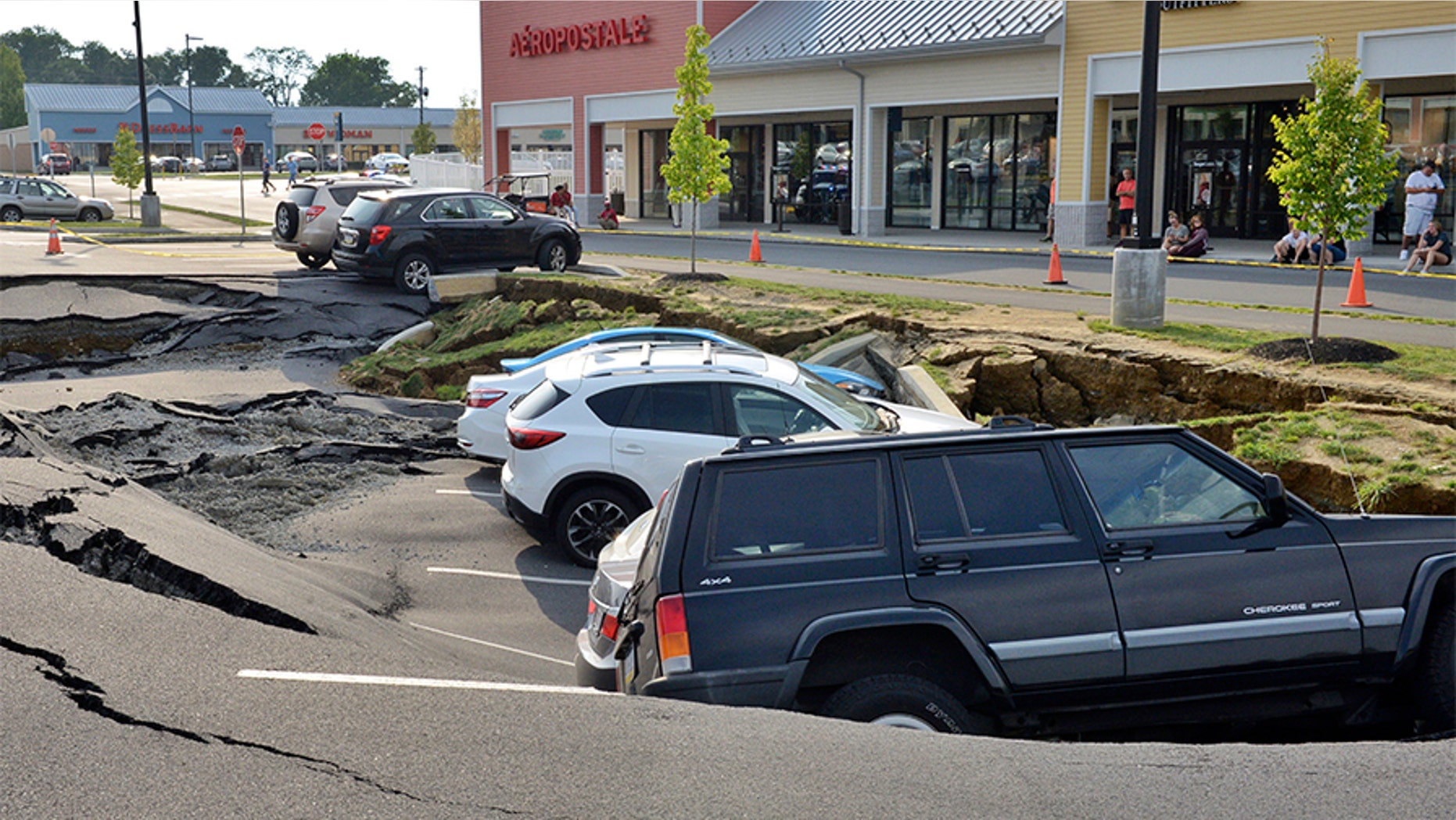 Vehicles sit at the bottom of a sinkhole that opened Friday in a parking lot at the Tanger Outlets shopping center in Lancaster, Pennsylvania.