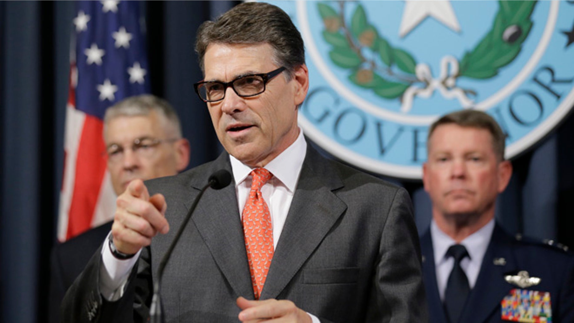 July 21, 2014: Gov. Rick Perry, center, speaks during a news conference in the Governor's press room in Austin, Texas.