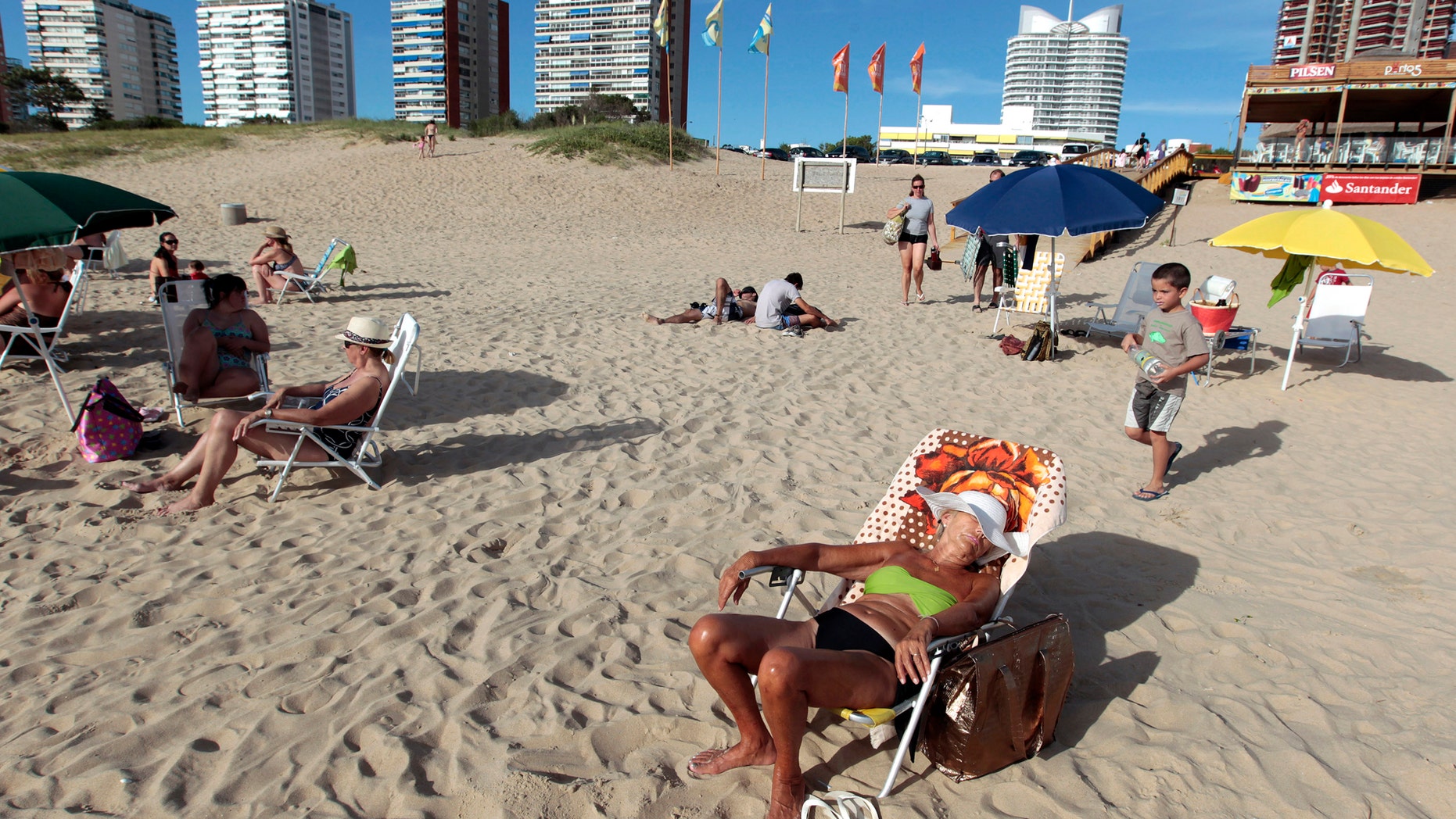 File photo: People sunbathe at the beach of the luxurious seaside resort of Punta del Este February 4, 2013. (REUTERS/Andres Stapff)