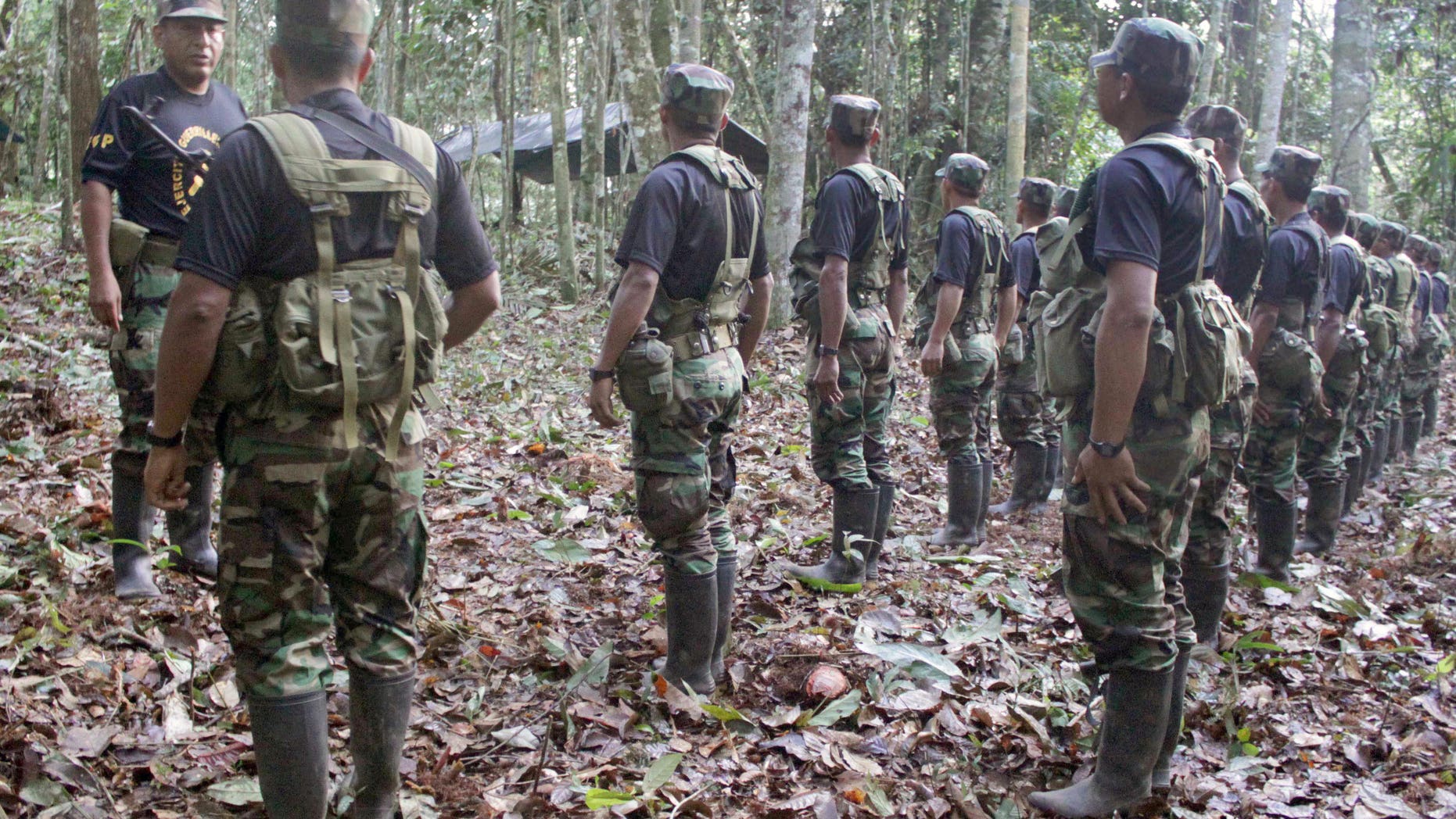This photo taken on Dec. 2, 2011, and released by IDL Reporteros, a Peruvian Website of Investigative Journalism, allegedly shows Jose Flores Hala, aka "Comrade Artemio", top left, one of the top leaders in activity of Peru's guerilla group Shining Path, giving instructions to his troops before an interview with IDL Reporteros at an unknown location of the Huallaga valley in Peru's Amazon region. During the interview,'Artemio' announced his troops will cease attacks and is calling for a truce to start peace negotiations with the government. (AP Photo/IDL Reporteros)