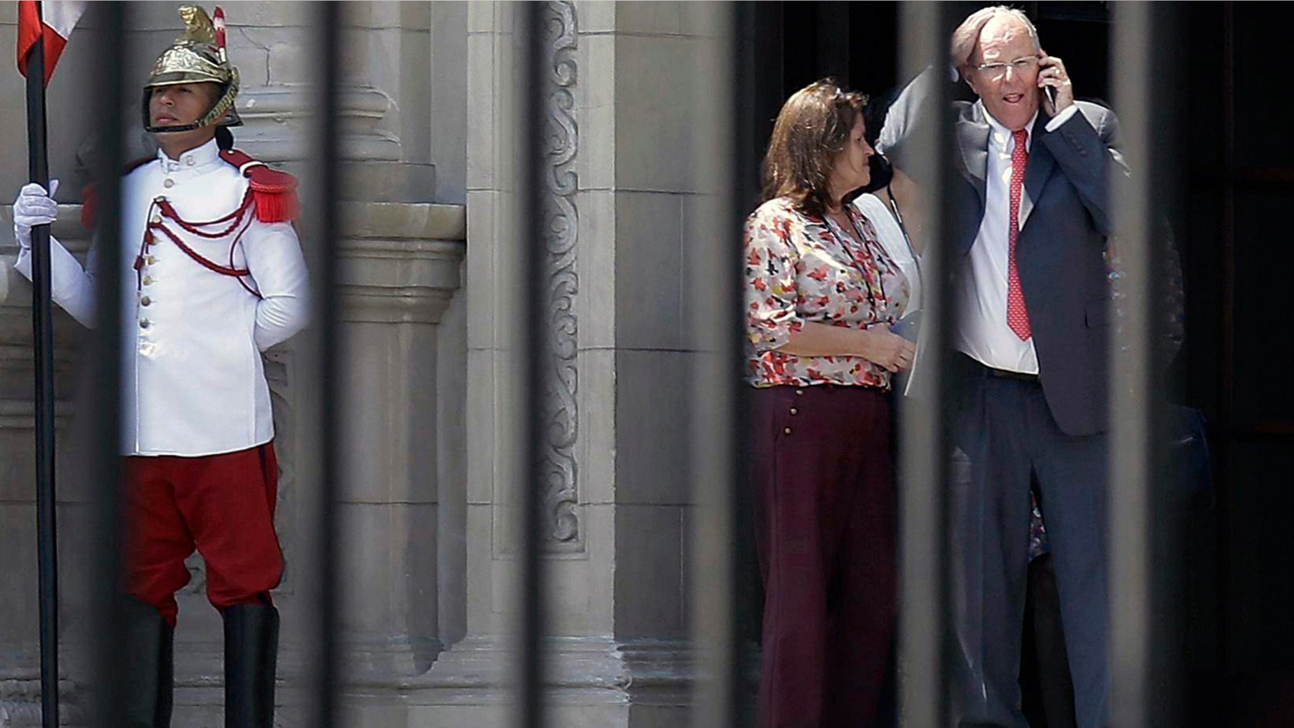 Peru's President Pedro Pablo Kuczynski talks on his cellphone as he leaves the Government Palace in Lima Wednesday.