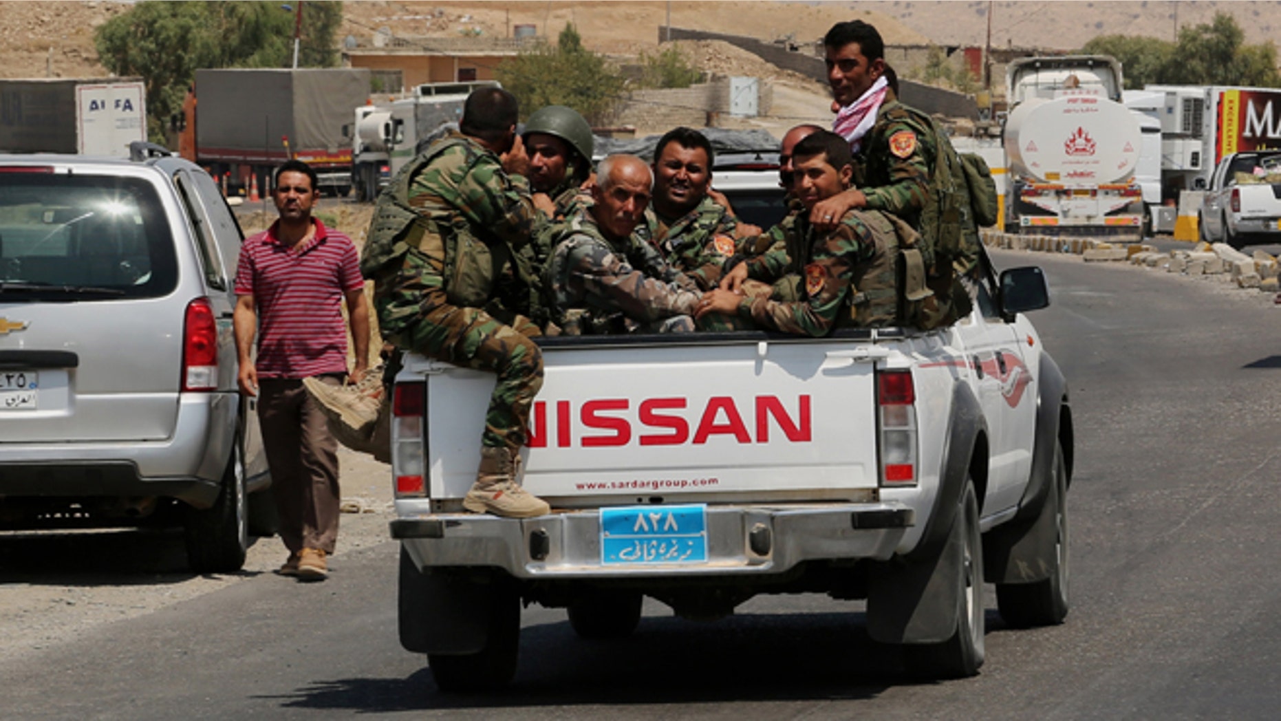Kurdish forces, known as the Peshmerga, make their way to the front line to fight militants from the extremist Islamic State group at Mosul Dam, outside Mosul, Iraq, Monday, Aug 18, 2014.