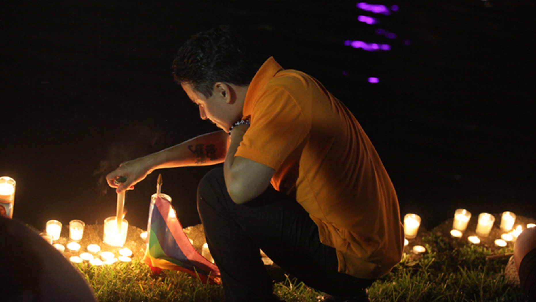 A mourner in Lake Eola Park lights a candle in memorium of the Pulse nightclub shooting victims.