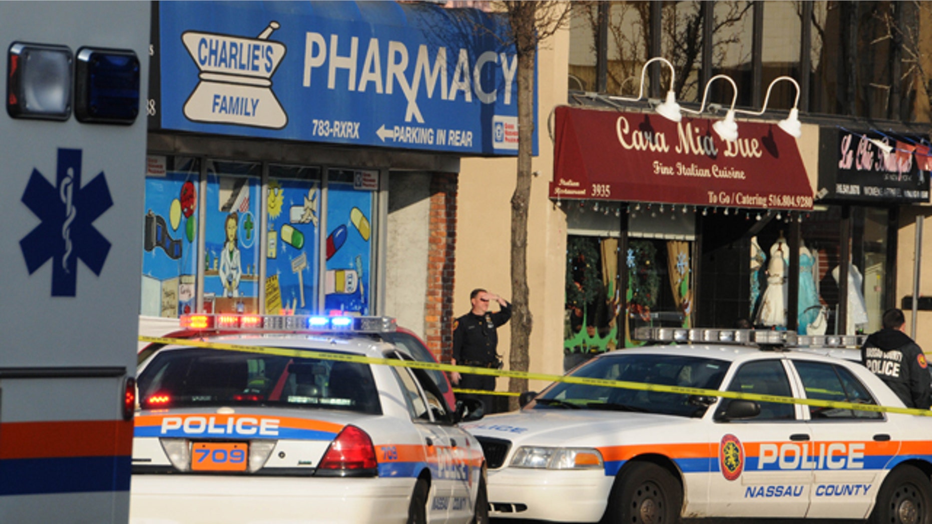 Dec. 31: A police officer stands on the sidewalk in front of Charlies Family Pharmacy in Seaford, N.Y., after a robber was killed while fleeing the store.