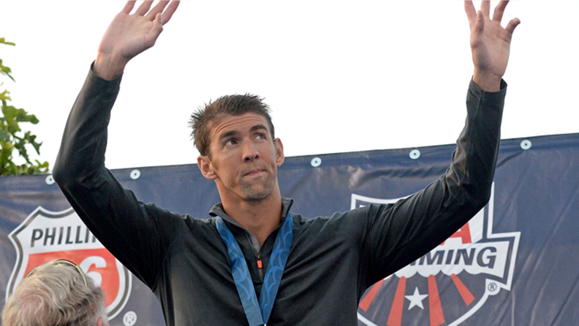 FILE 2014: Michael Phelps on the podium after getting his second place medal for the Men's 100 Meter Butterfly final at the USA Swimming Nationals at the William Woollett Jr. Aquatics Complex.
