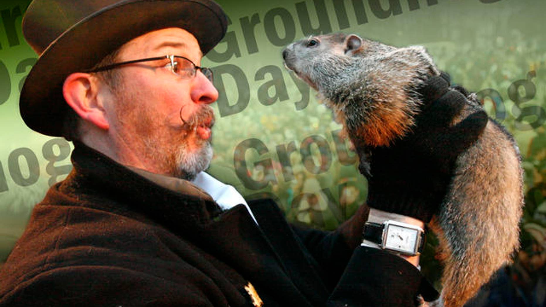 Punxsutawney Phil, right, is held by Ben Hughes after emerging from his burrow on Gobblers Knob in Punxsutawney, Pa., to see his shadow and forecast six more weeks of winter weather Tuesday, Feb. 2, 2010. (AP Photo/Gene J. Puskar)