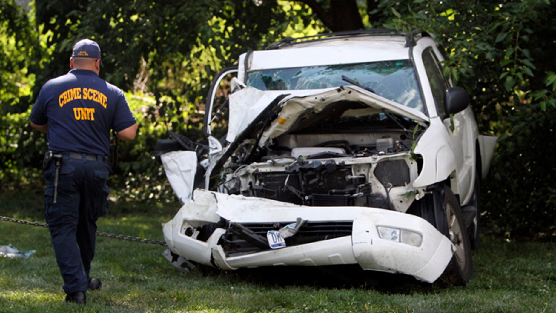 July 25, 2014: An investigator examines a heavily damaged SUV before it is towed from the scene of a fatal accident in North Philadelphia.