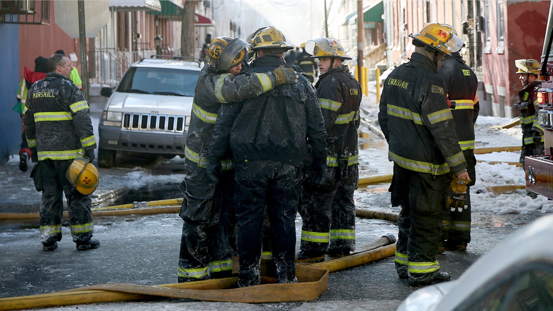 Firefighters embrace after putting out the deadly blaze on North Colorado Street in North Philadelphia.