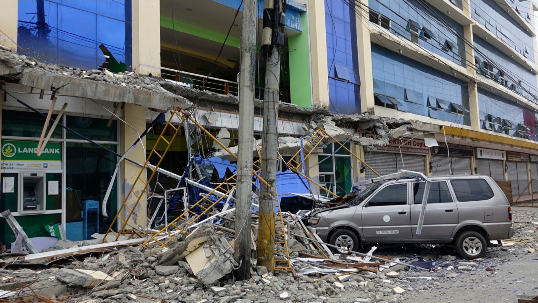 Fallen debris from a building are seen Saturday, Feb. 11, 2017 following a powerful nighttime earthquake that rocked Surigao city, Surigao del Norte province in southern Philippines.