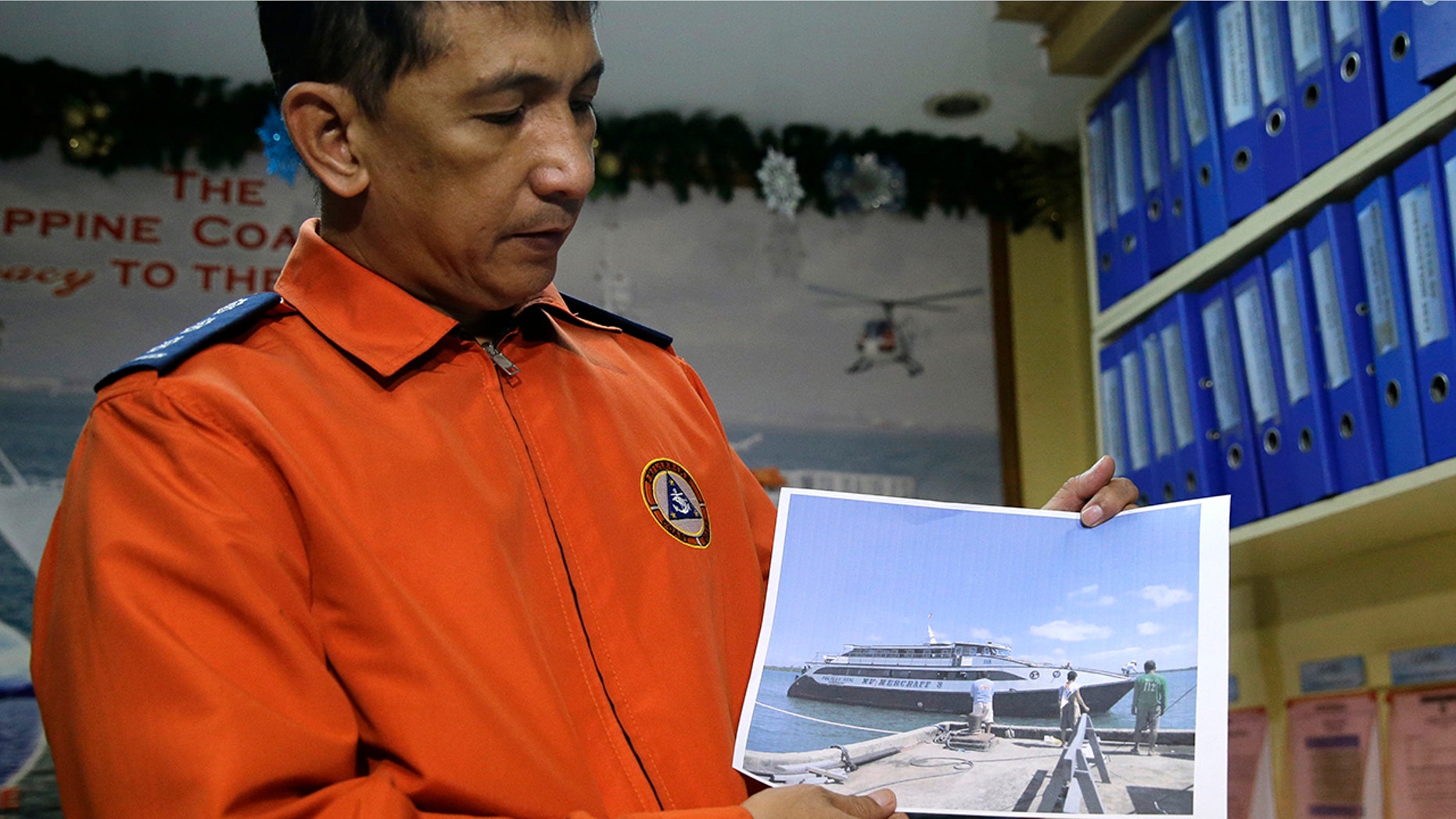 Coast guard spokesman Armand Balilo shows a file photo of the passenger vessel Mercraft 3 as he talks to reporters in Manila, Dec. 21, 2017.