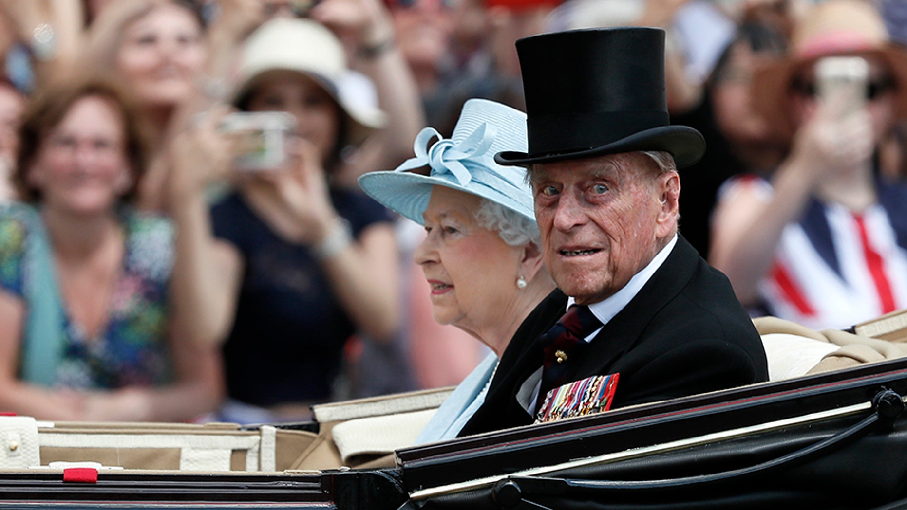 Britain's Queen Elizabeth II and Prince Philip return to Buckingham Palace in a carriage, after attending the annual Trooping the Color Ceremony, June 17, in London. Buckingham Palace said on Wednesday June 21, 2017, Prince Philip is good spirits after being admitted to hospital.