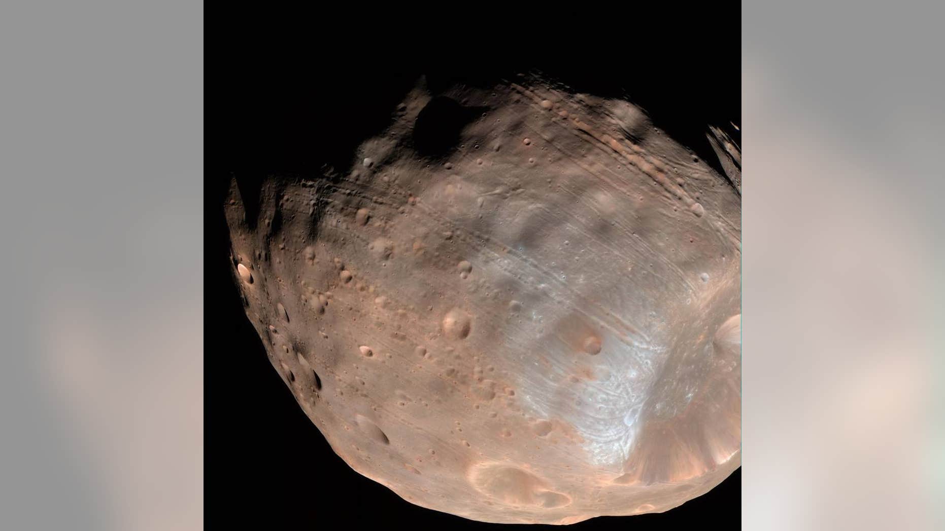 New modeling indicates that the grooves on Mars’ moon Phobos could be produced by tidal forces – the mutual gravitational pull of the planet and the moon. Initially, scientists had thought the grooves were created by the massive impact that made Stickney crater (lower right). (NASA/JPL-Caltech/University of Arizona)