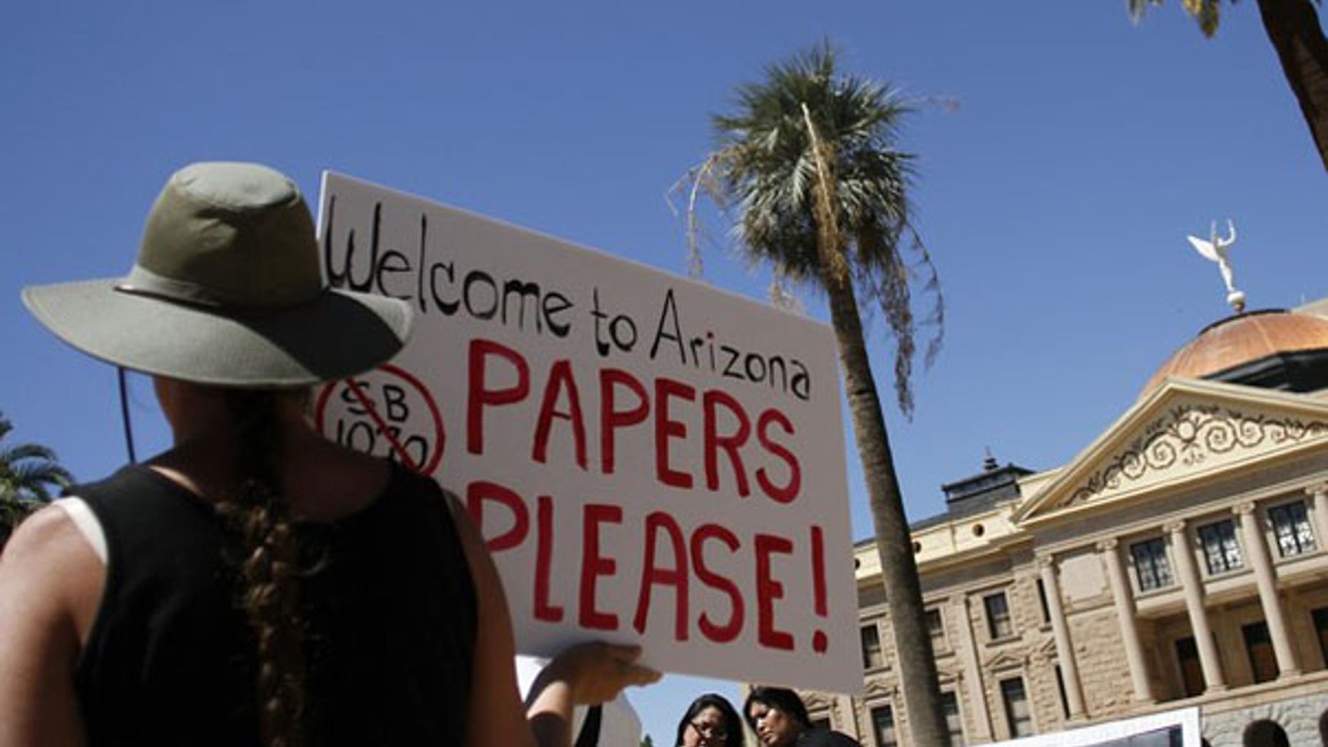 A demonstrator holds a sign during an immigration rally in Phoenix May 1. (Reuters Photo)
