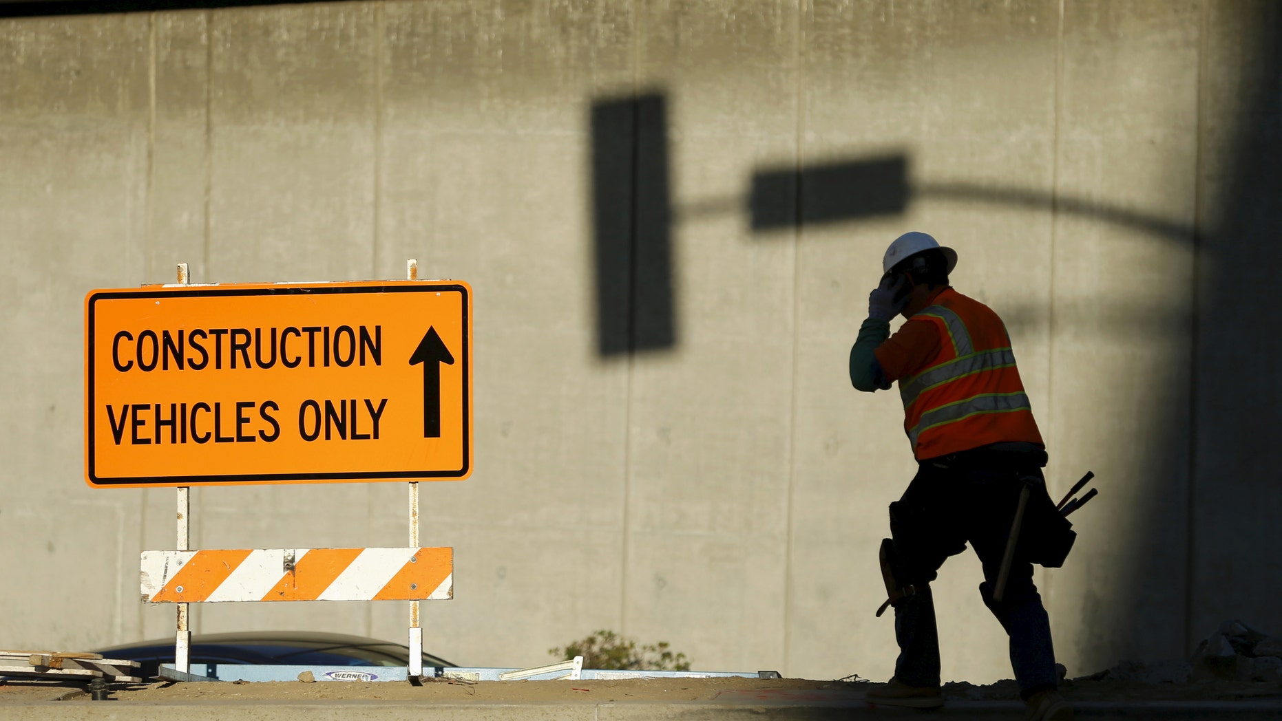 A worker talks on a mobile phone from a downtown construction site in Los Angeles, Calif. Jan. 29, 2016. (REUTERS/Mike Blake)