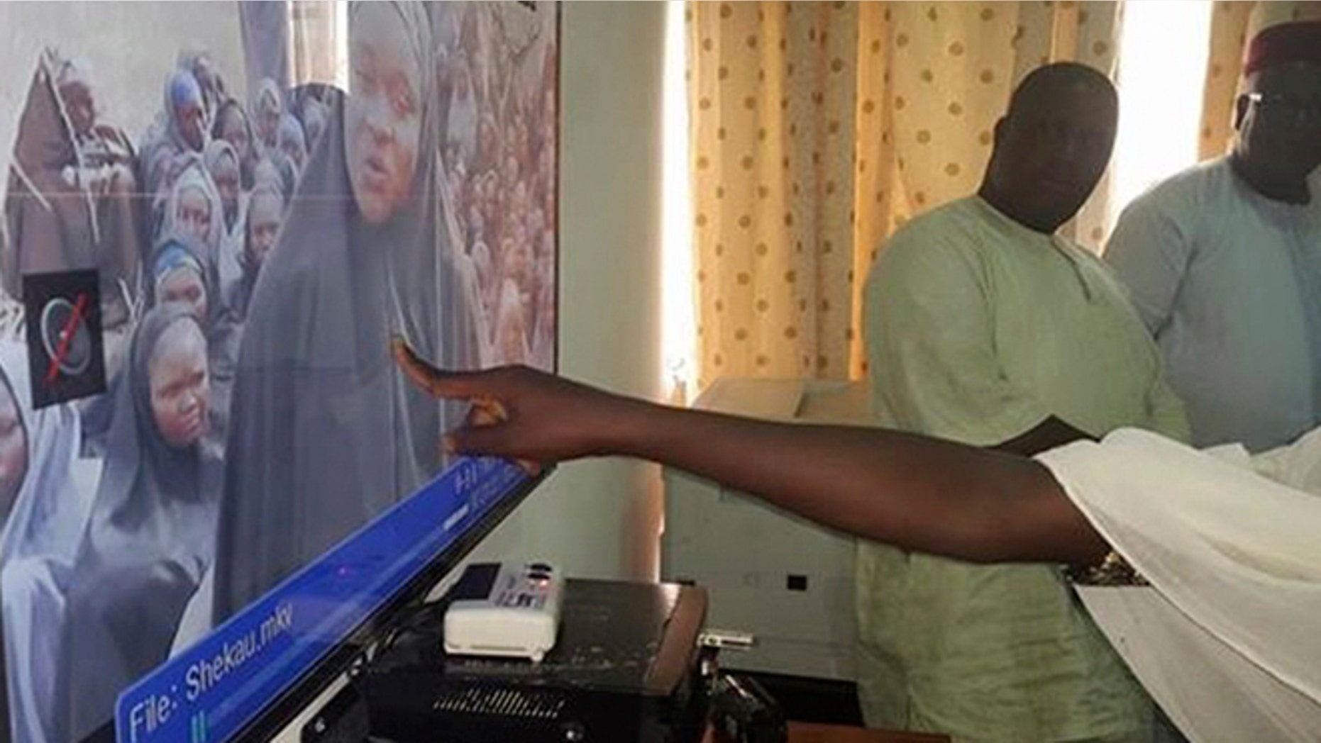 FILE 2014: A student who escaped when Boko Haram rebels stormed a school in May and abducted schoolgirls, identifies her schoolmates from a video released by the Islamist rebel group at the Government House in Maiduguri, Borno State.