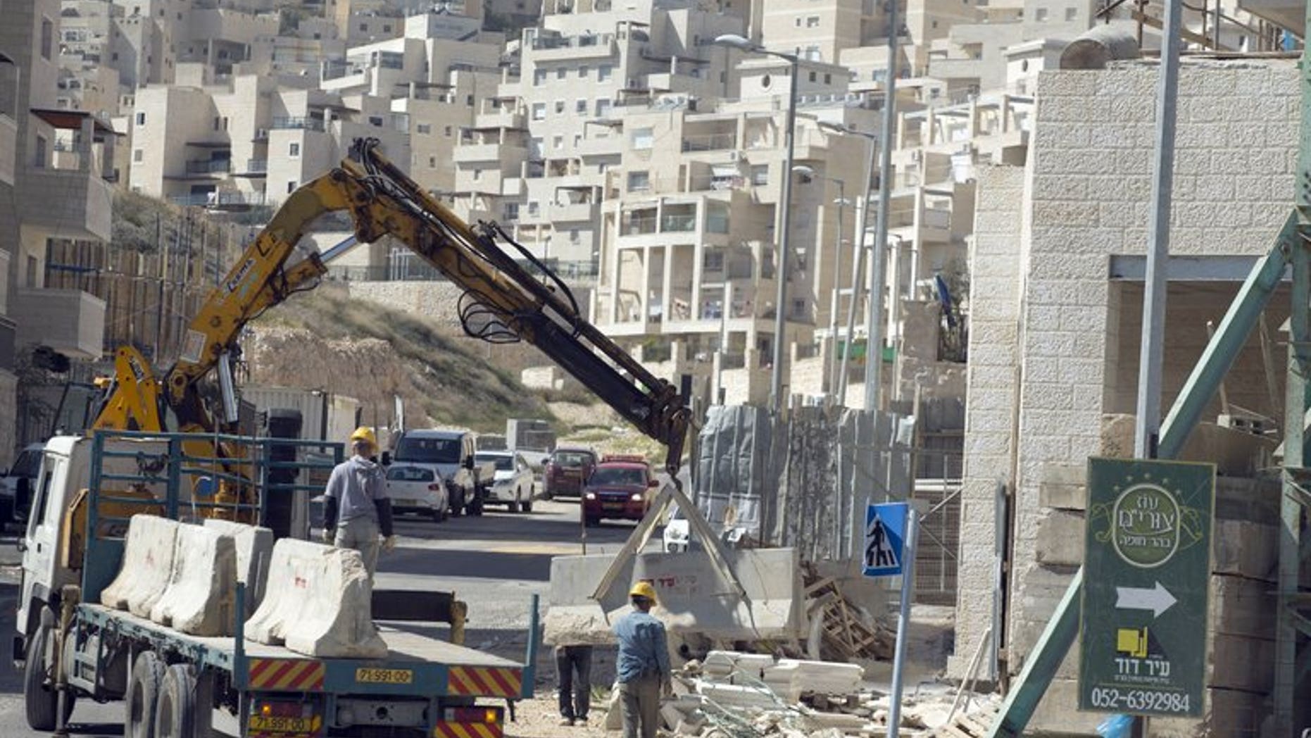 Labourers work at a housing construction site in the Israeli settlement of Har Homa in east Jerusalem on February 27, 2013. Israeli Housing Minister Uri Ariel implied that a silent freeze on new housing projects in east Jerusalem and the West Bank has been in place since the beginning of 2013.