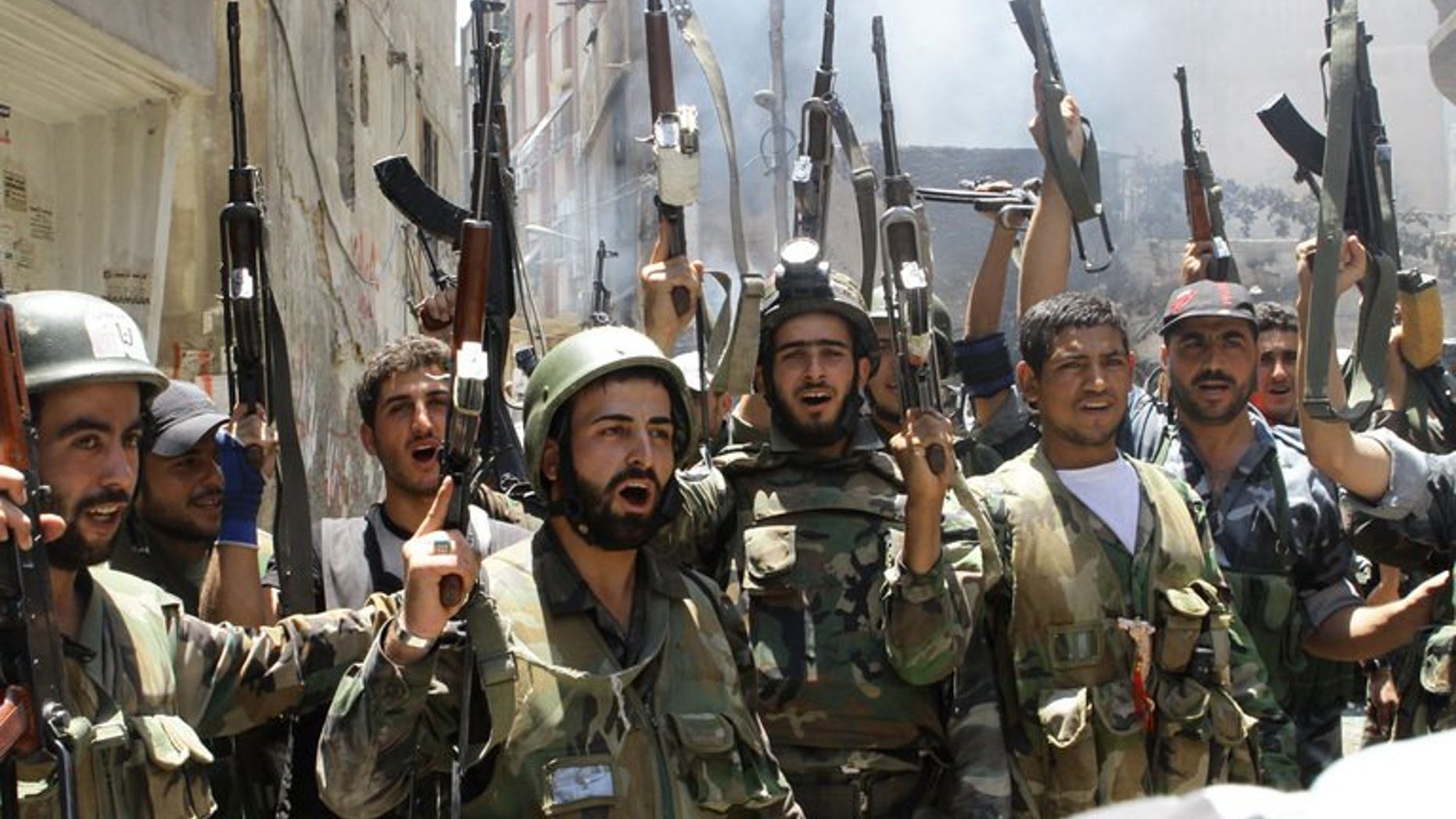 Syrian soldiers celebrate in the al-Midan area in Damascus on July 20, 2012. Troops loyal to Syrian President Bashar al-Assad pushed forward a bid to crush rebel bastions near the capital Damascus, a monitoring group and activists said.