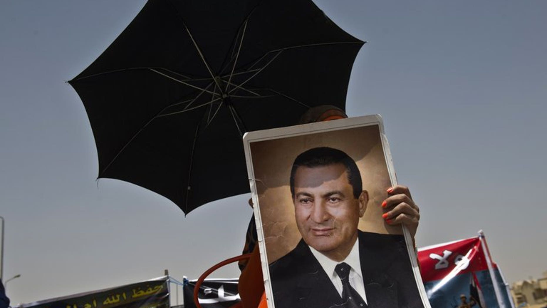 A supporter of Hosni Mubarak holds a portrait of him outside the court in Cairo last week during his retrial. An Egyptian court on Tuesday ended Mubarak's detention in one corruption case, judicial sources told AFP, but the ousted president will remain in custody on other charges.