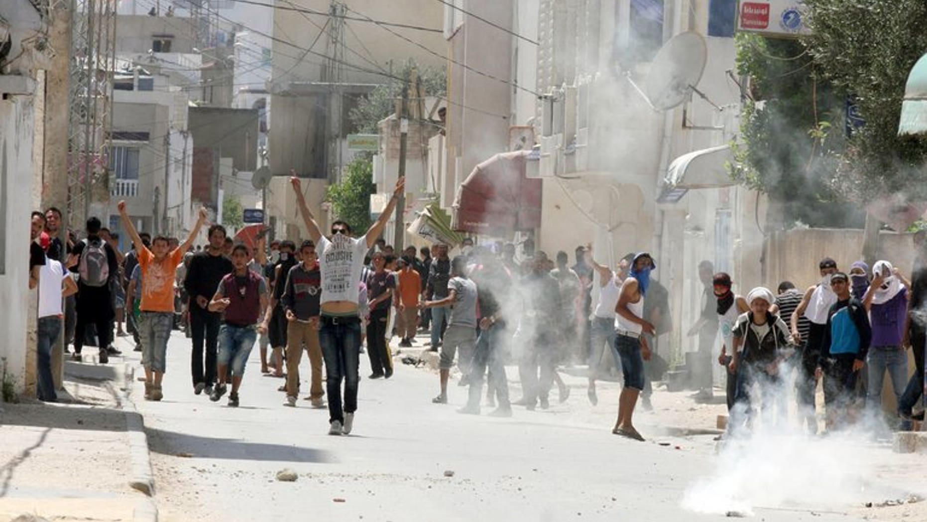 Tunisian police fire tear gas at radical Islamists in Ettadhamen, west of Tunis, in May. Six people belonging to Tunisia's hardline Salafist movement have each been handed five year jail sentences for torching an important Sufi shrine, the country's Sufi union said on Tuesday.