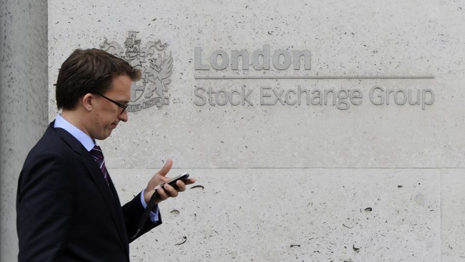 A man walks past the London Stock Exchange, in central London. London shares closed higher on Tuesday as investors hoped the two-day Federal Reserve Board meeting will not spark too sharp a reduction in the Fed's stimulus programme to shore up the United States economy, dealers said.