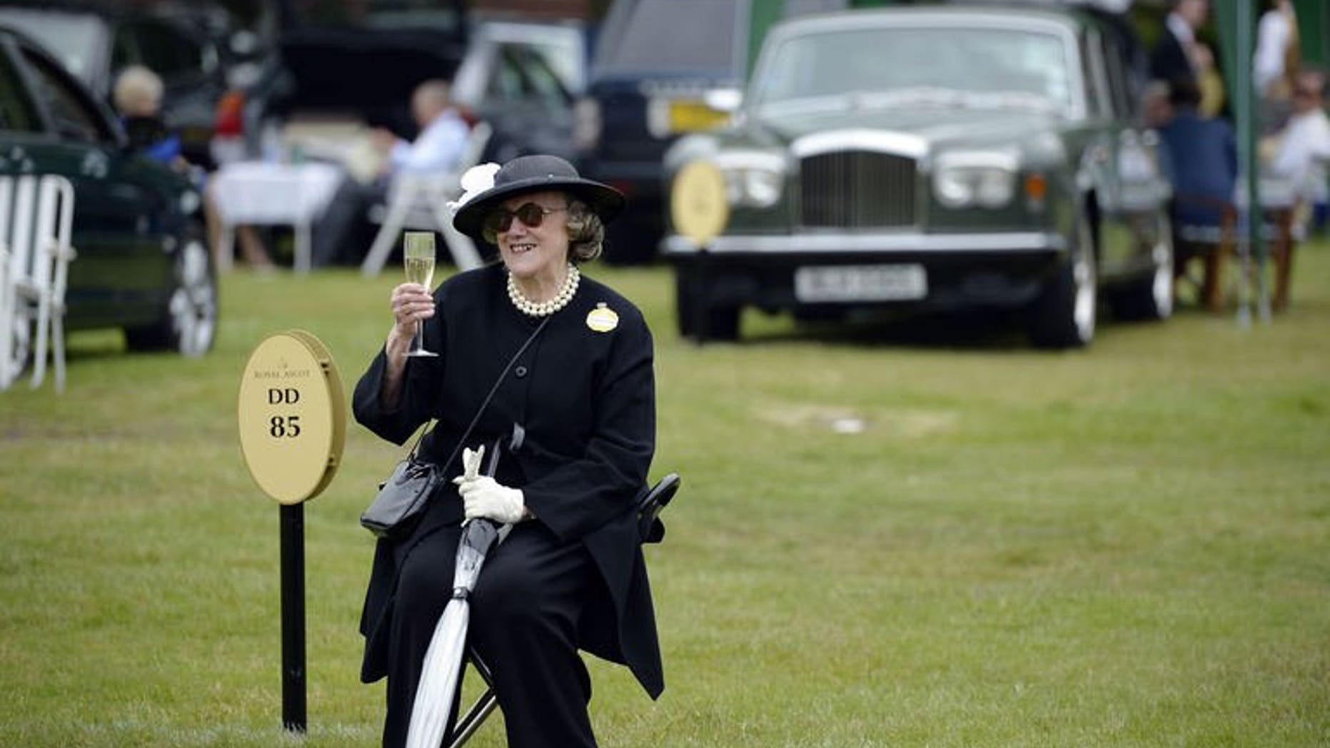 A racegoer raises a glass of champagne while she waits for friends during the first day of Royal Ascot, in Berkshire, west of London, on June 18, 2013. Ireland dominated the opening day of the Royal Ascot meeting on Tuesday carrying all before them in the first four races including the feature race the St James's Palace Stakes.
