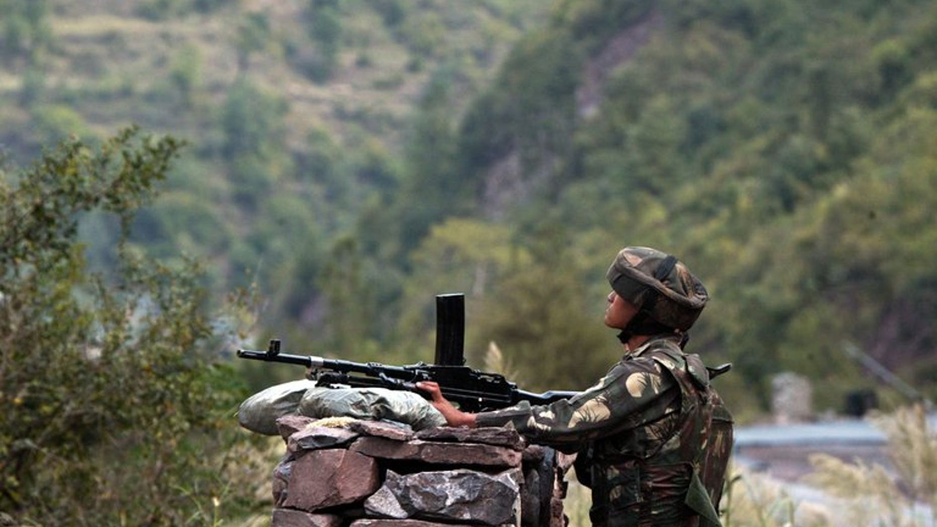 An Indian army soldier looks towards the Pakistani side on the Indian side of Line of Control (LOC) near Kaman post on October 9, 2008. A Pakistani woman was injured Tuesday when Indian troops fired across the disputed border in the Himalayan region of Kashmir, Pakistan's military said.