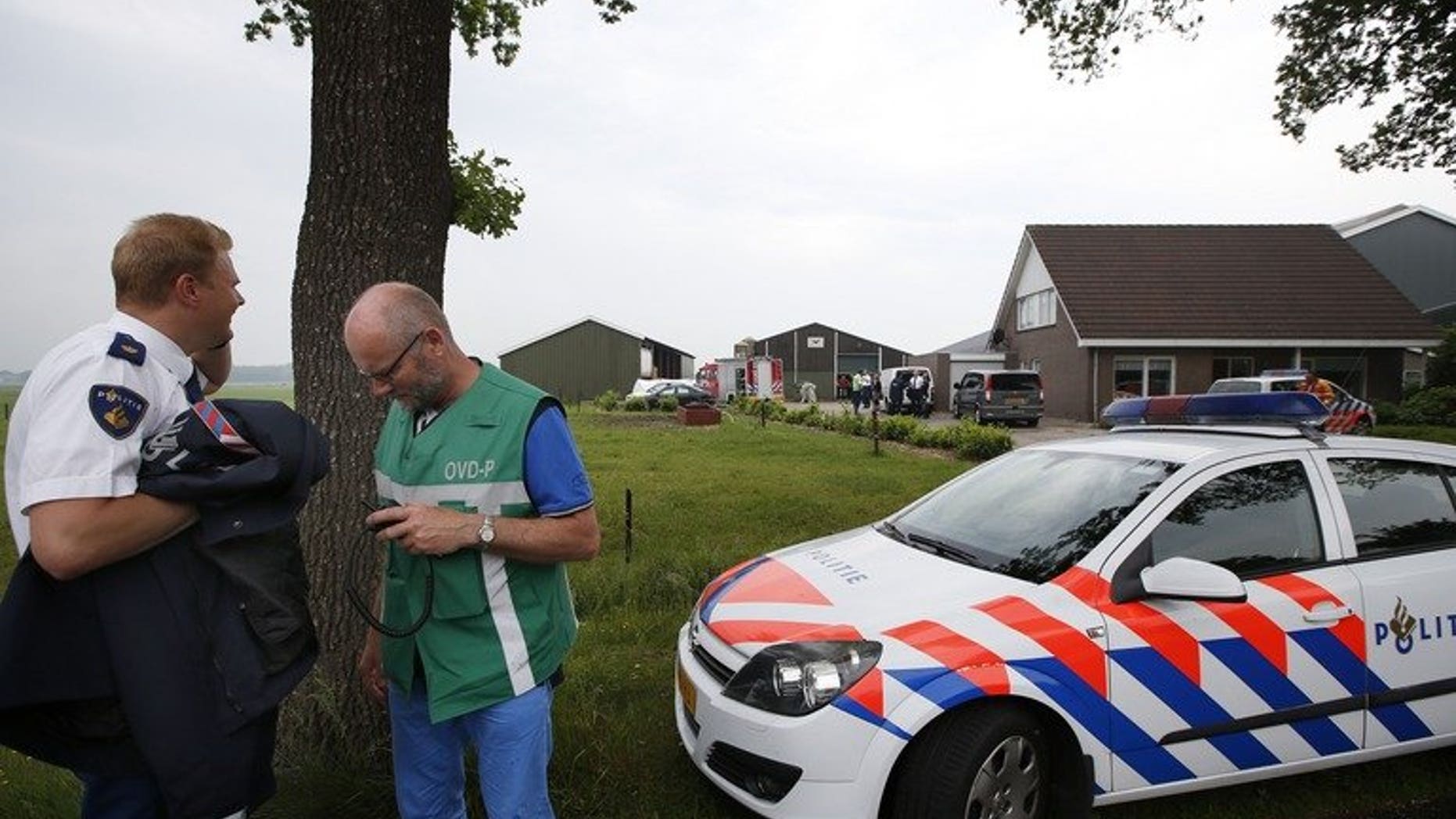 Policemen and rescue workers stand in front of a farm in Makkinga in northern Netherlands, where three men were killed and on man injured after an accident in a manure silo on June 19, 2013. Three farmworkers died after falling into a manure silo in the northern Netherlands, with a survivor flown to hospital in a critical condition