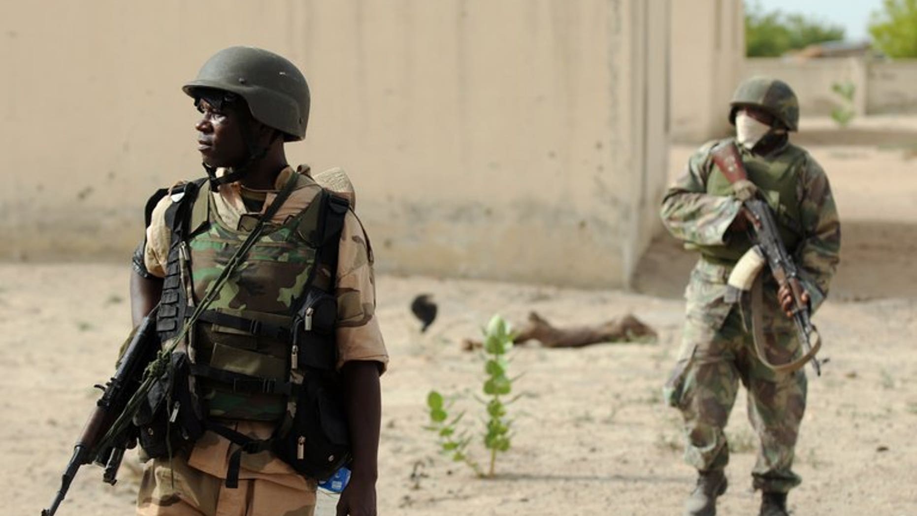 Nigerian soldiers patrol in the north of Borno state on June 5, 2013 near a deserted Boko Haram camp. Nigeria's military has banned the use of satellite phones in much of the restive northeast after cutting mobile phone service, further isolating the area after a series of fresh attacks.