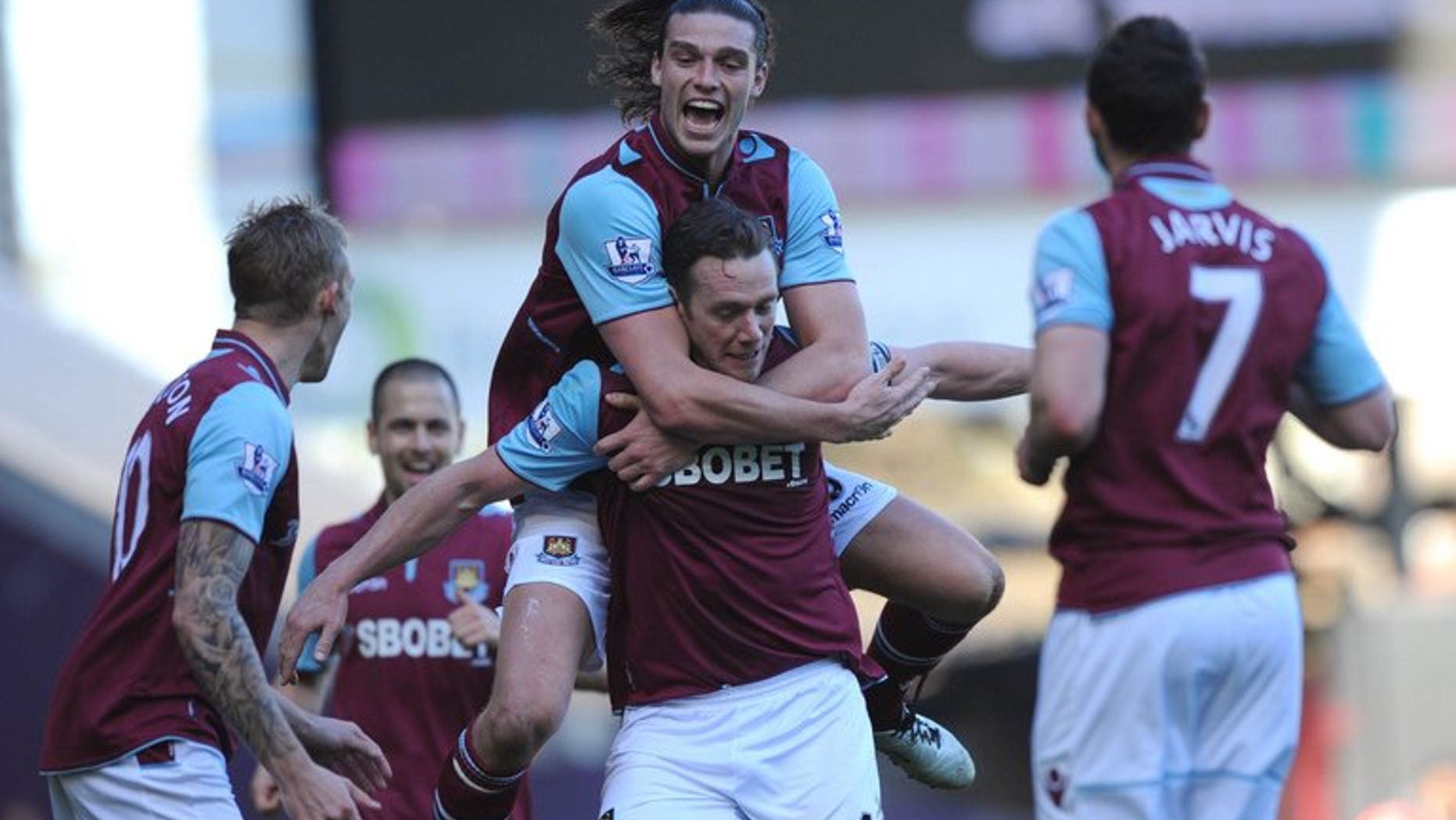 Andy Carroll (top) helps Kevin Nolan (below) celebrate a goal for West Ham against Wigan at Upton Park on April 20. England striker Carroll has completed his move from Liverpool to West Ham United, the east London club says.
