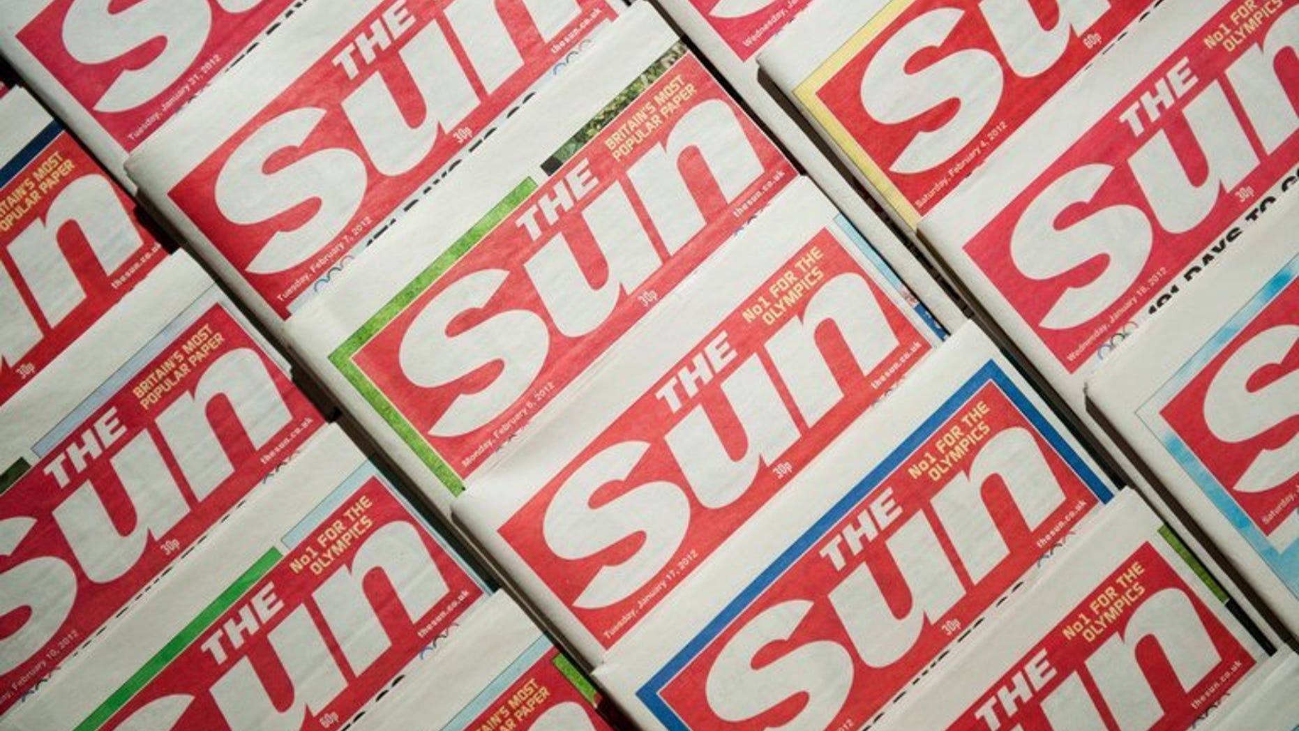 Picture shows an arrangement of copies of The Sun tabloid on February 13, 2012. Two journalists from Rupert Murdoch's The Sun were charged in Britain on Friday, accused of paying officials for information about hospital patients, the royal family and ongoing police investigations.